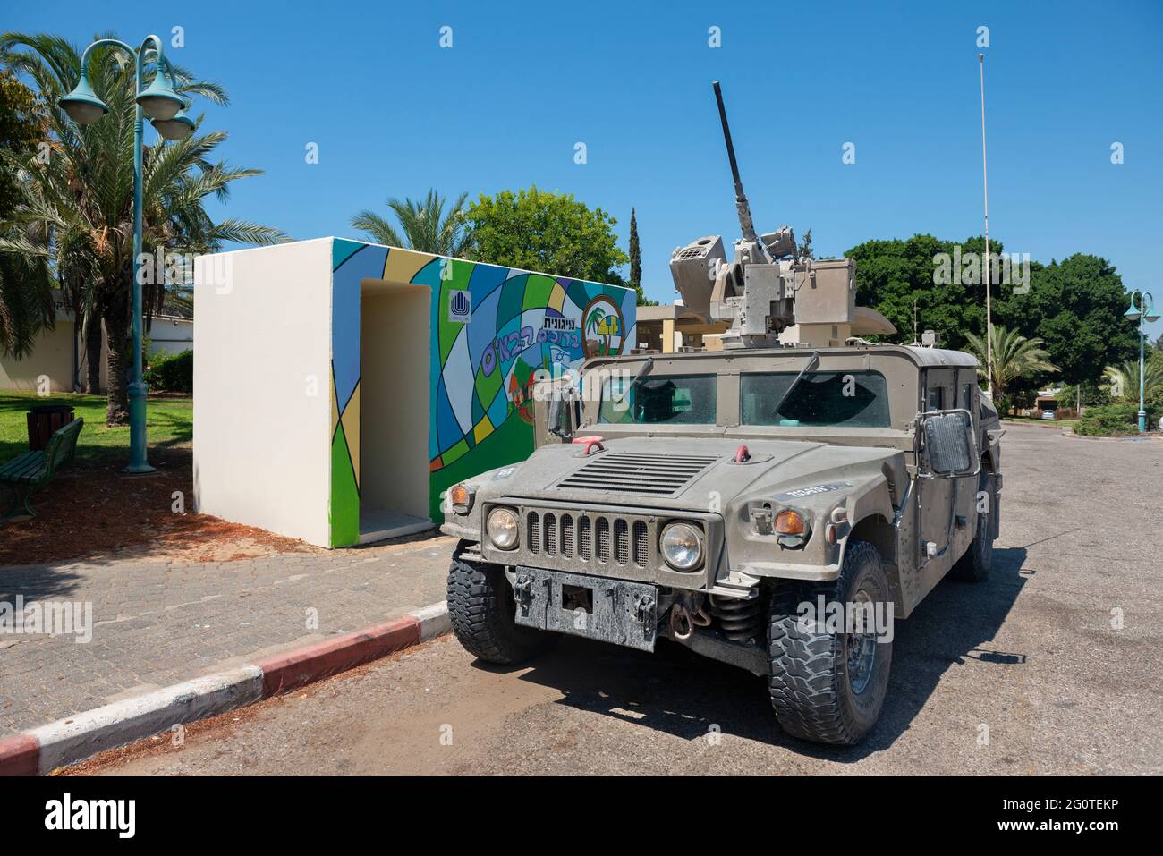 Joint Light Tactical Vehicle vor einer Bombenschutzhütte in Netiv HaAsara neben dem Busstand. Netiv HaAsara ist ein Moshav, südlich von Israel an der Grenze zu Gaza. Stockfoto