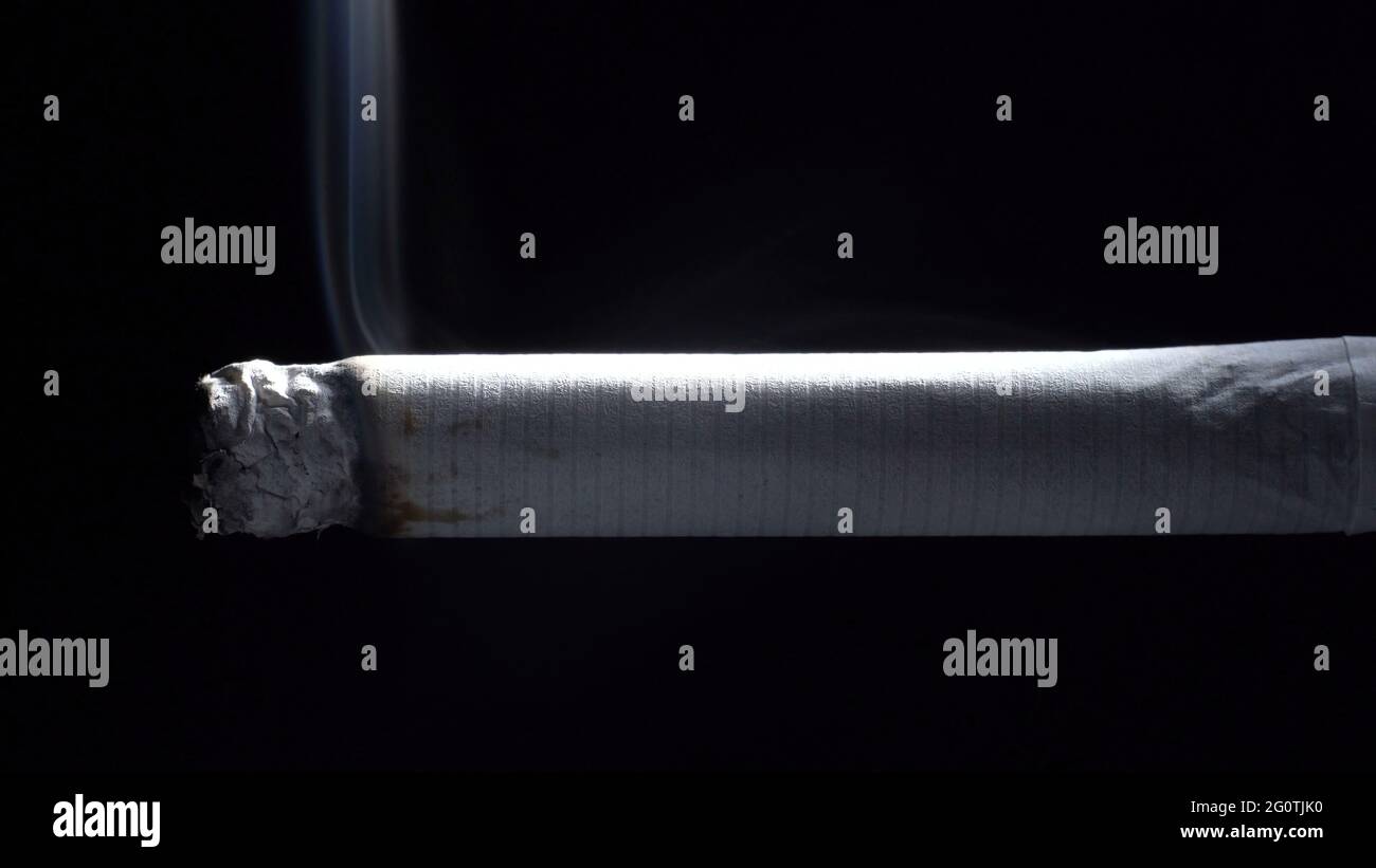 Foto von schwelender Zigarette und Asche auf Schwarz Stockfoto