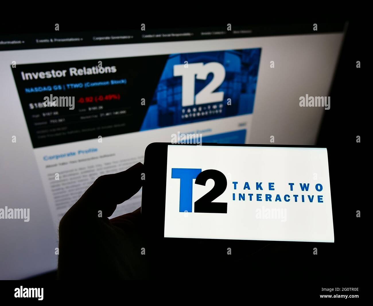 Person, die ein Mobiltelefon mit dem Logo der Videospielfirma Take-Two Interactive Software Inc. Auf dem Bildschirm vor der Webseite hält. Konzentrieren Sie sich auf die Telefonanzeige. Stockfoto