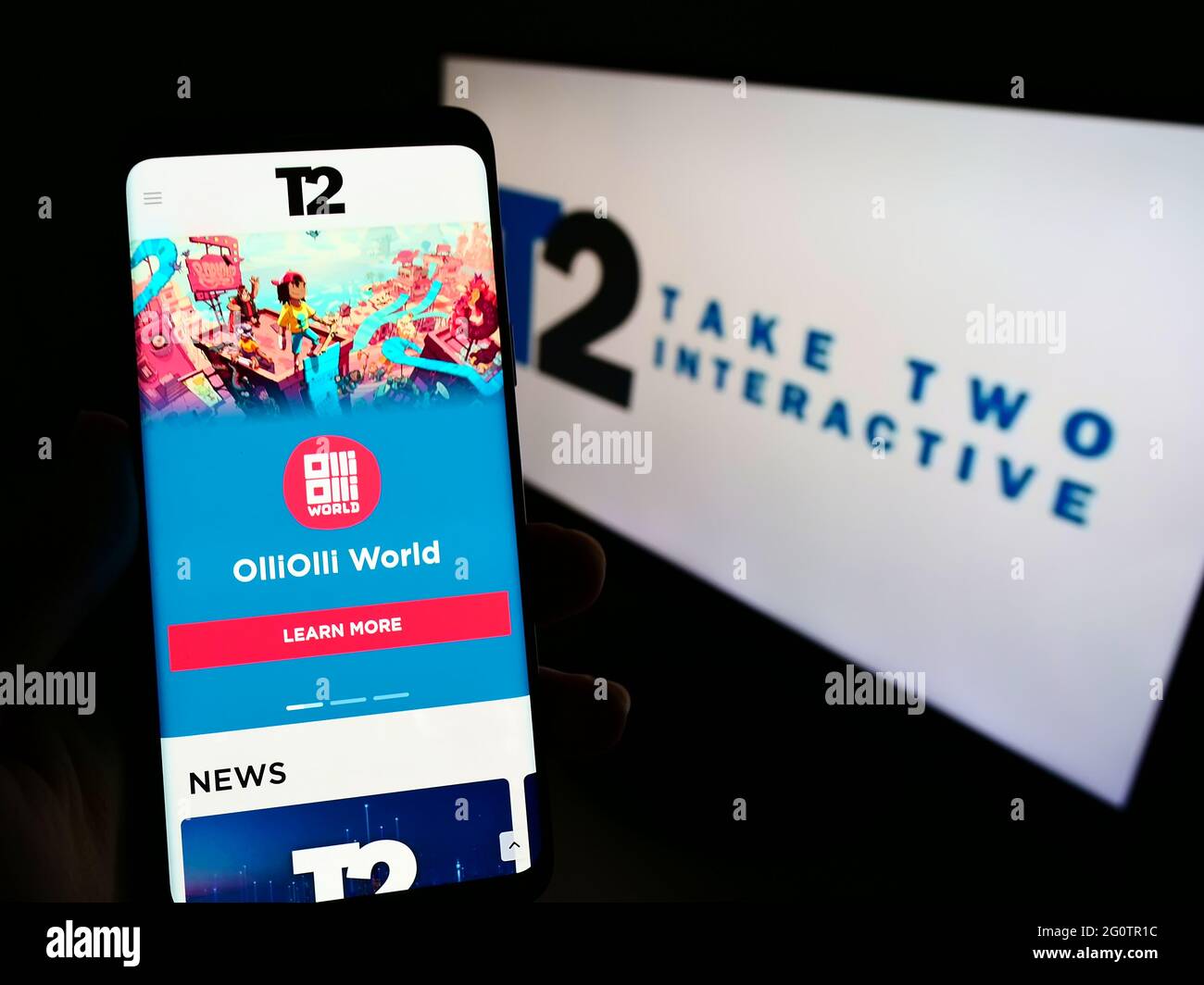 Person, die Smartphone mit Website der Videospielfirma Take-Two Interactive Software Inc auf dem Bildschirm mit Logo hält. Konzentrieren Sie sich auf die Mitte des Telefondisplays. Stockfoto