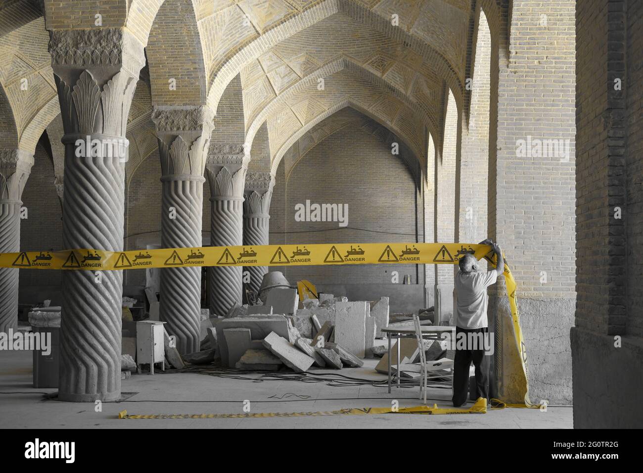 Ein alter Mann, der in einer wunderschönen alten Moschee im Iran ein Schild mit der Aufschrift „Zorn, kein Eindringen“ aufstellte. Stockfoto