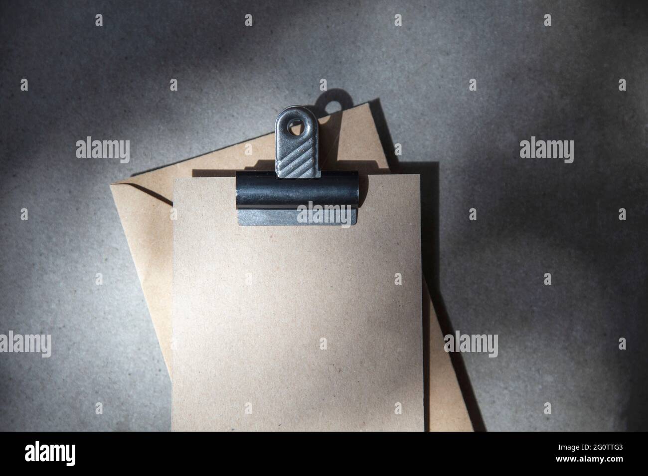 Weiße braune Einladung oder Postkarte mit Umschlag unter strahltem Sonnenlicht Stockfoto
