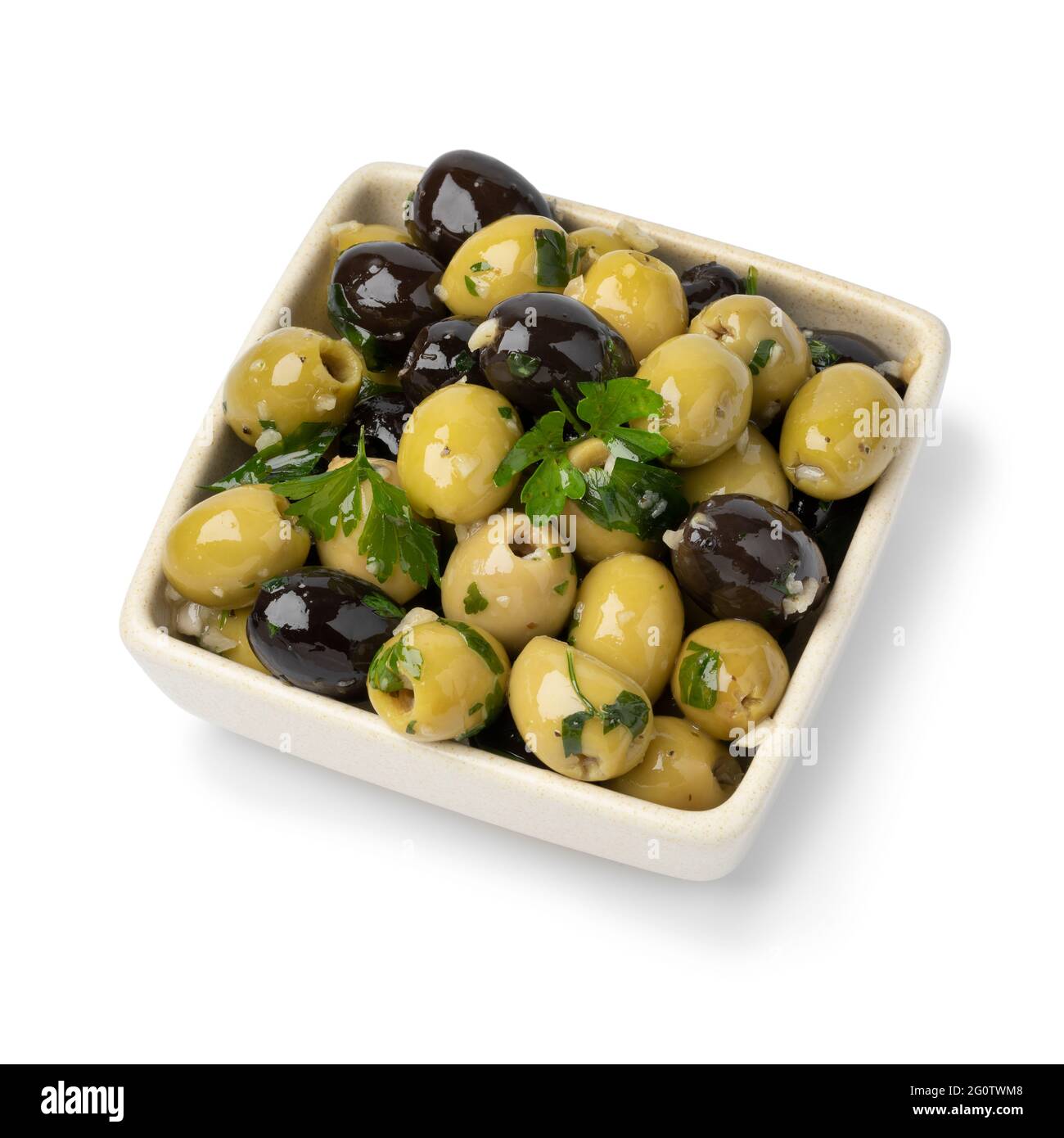 Schüssel mit grünen und schwarzen Oliven gewürzt mit Knoblauch und Kräutern isoliert auf weißem Hintergrund Stockfoto