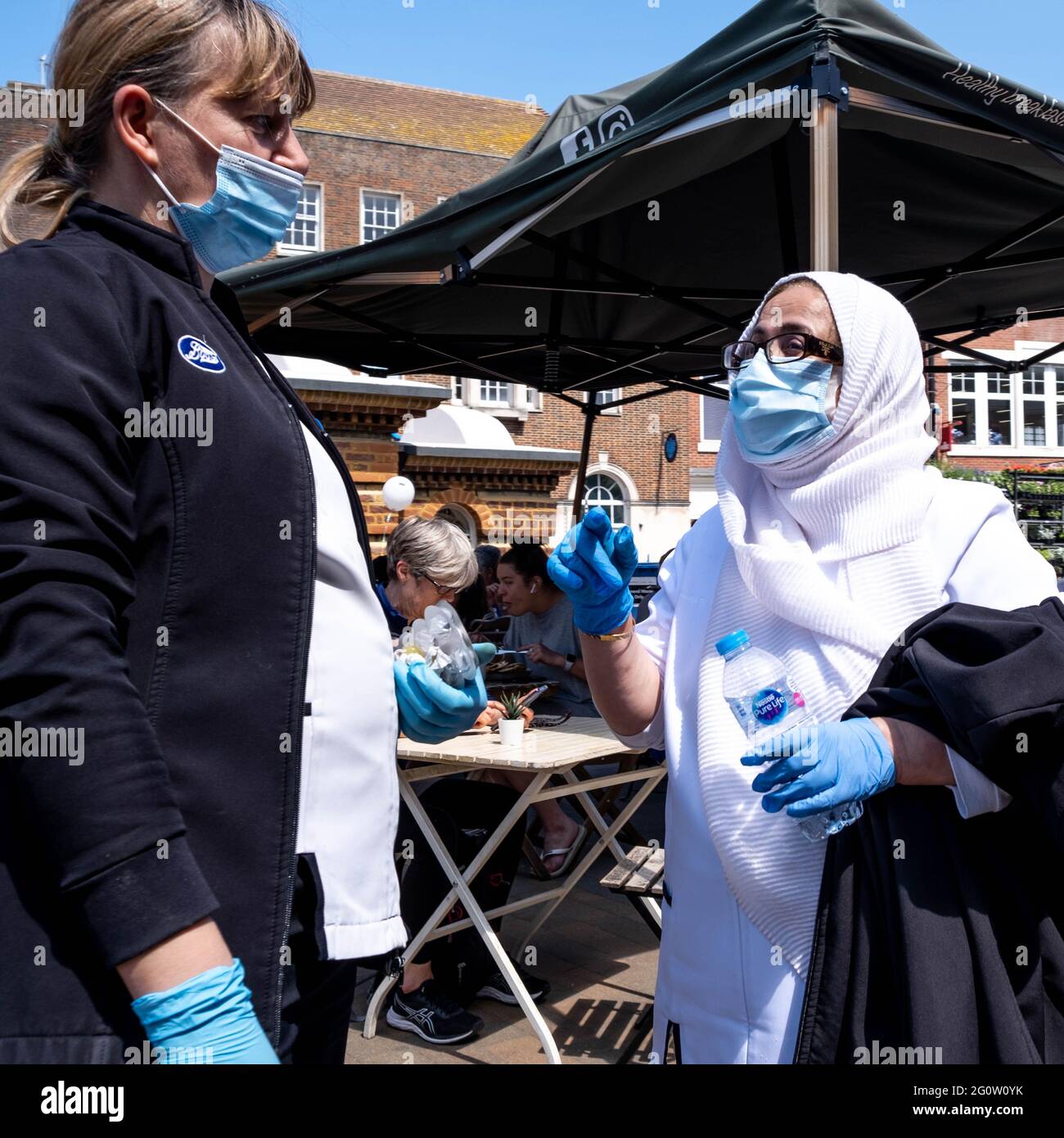 Epsom Surrey London, Großbritannien, 03 2021. Juni, zwei Frauen tragen Schutzgesichtenmasken oder decken sich im Stehen sprechend eine Muslimin, die einen Hijab trägt Stockfoto