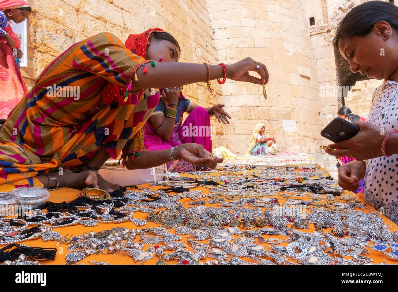 Jaisalmer, Rajasthan, Indien - 13. Oktober 2019 : Rajasthani Frauen verkaufen und verhandeln Preis von Schmuck mit weiblichen Touristen auf dem Markt. Stockfoto