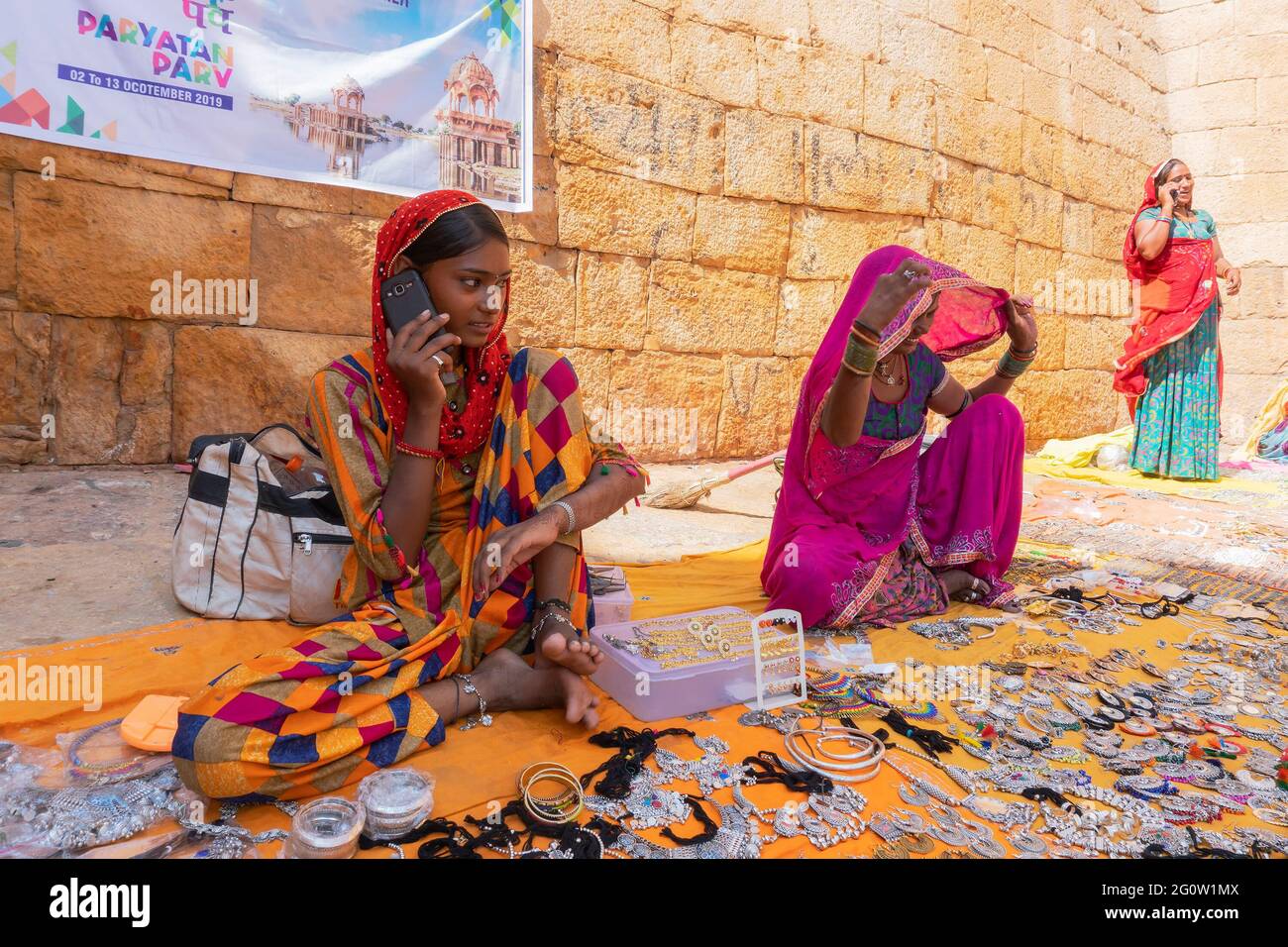 Jaisalmer, Rajasthan, Indien - 13. Oktober 2019 : Rajasthani Frauen sprechen in Mobiltelefonen und Verkauf von Schmuck auf dem Markt in Jaisalmer Fort. Stockfoto