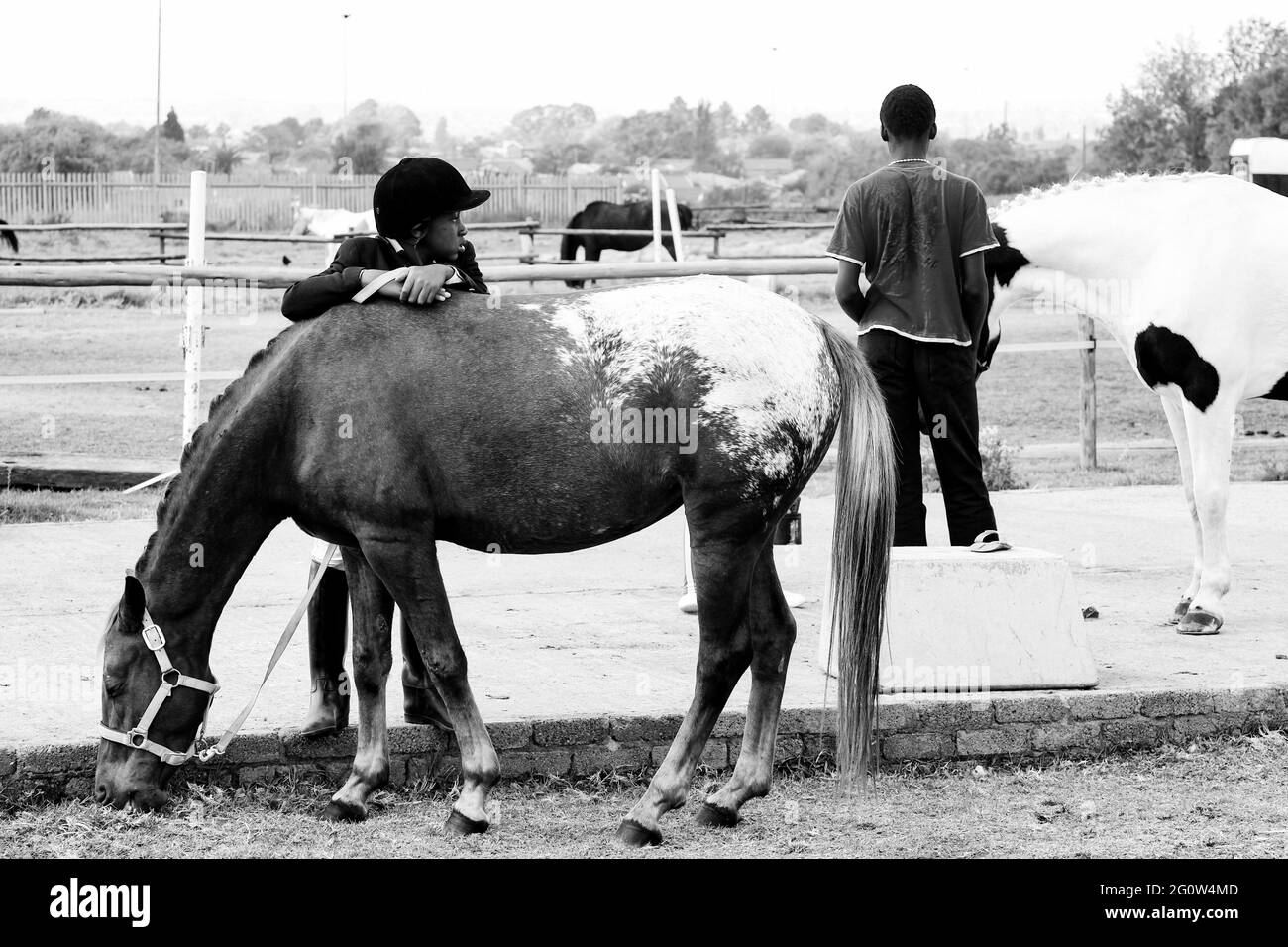 JOHANNESBURG, SÜDAFRIKA - 06. Jan 2021: Soweto, Südafrika - 16. April 2012: Junges afrikanisches Kind, das die Arme auf einem Pferd ruht Stockfoto