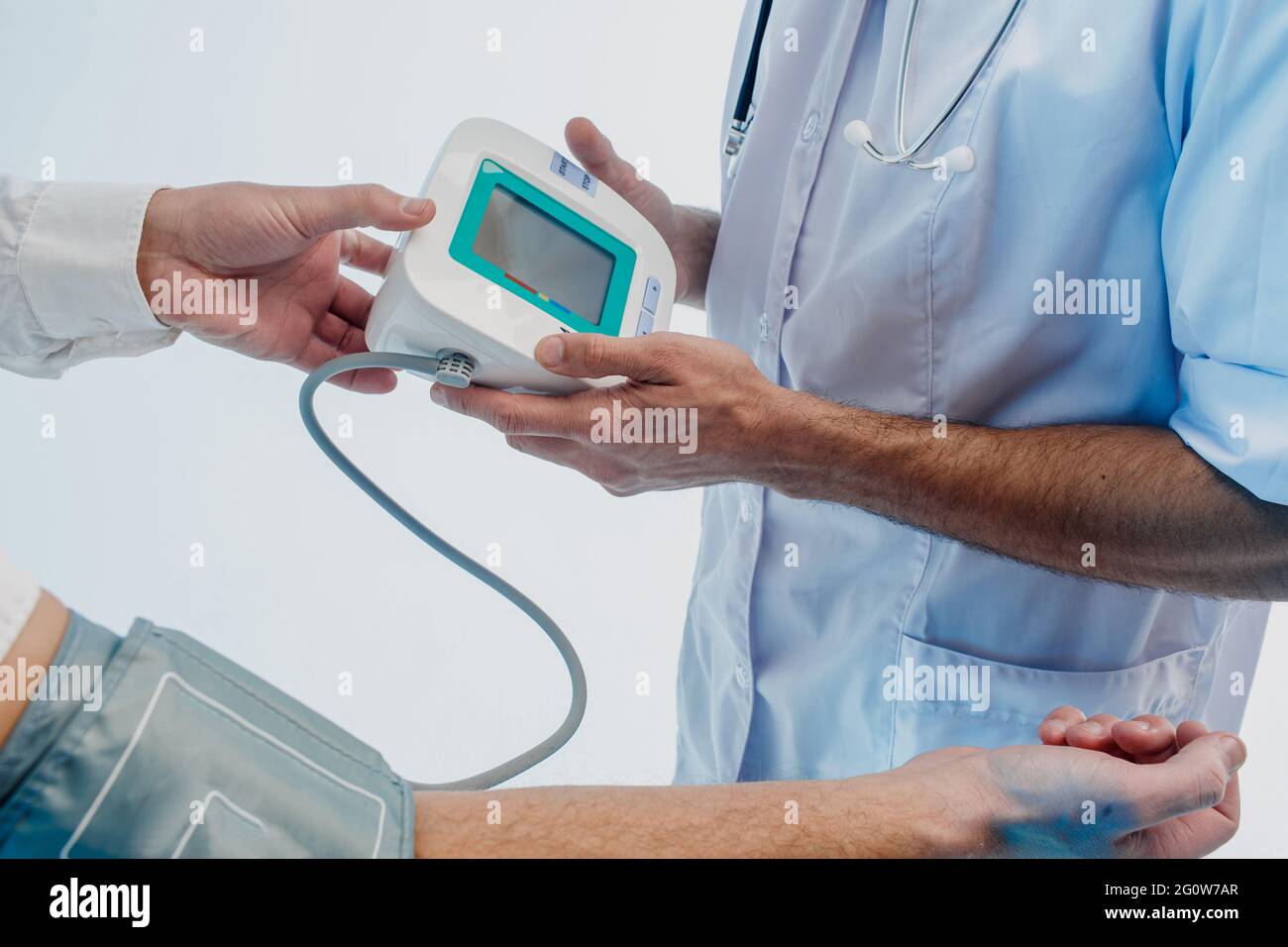 Ärztliches Prüfen des Pulses des Patienten mit Tonometer Stockfoto