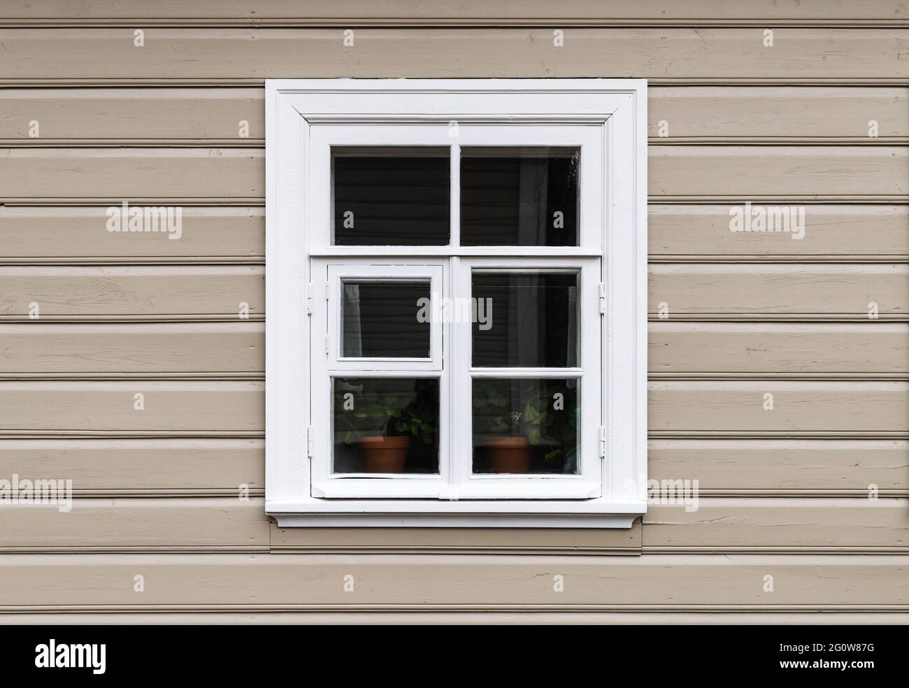 Fenster mit weißem Holzrahmen in einer beigefarbenen Wand Stockfoto