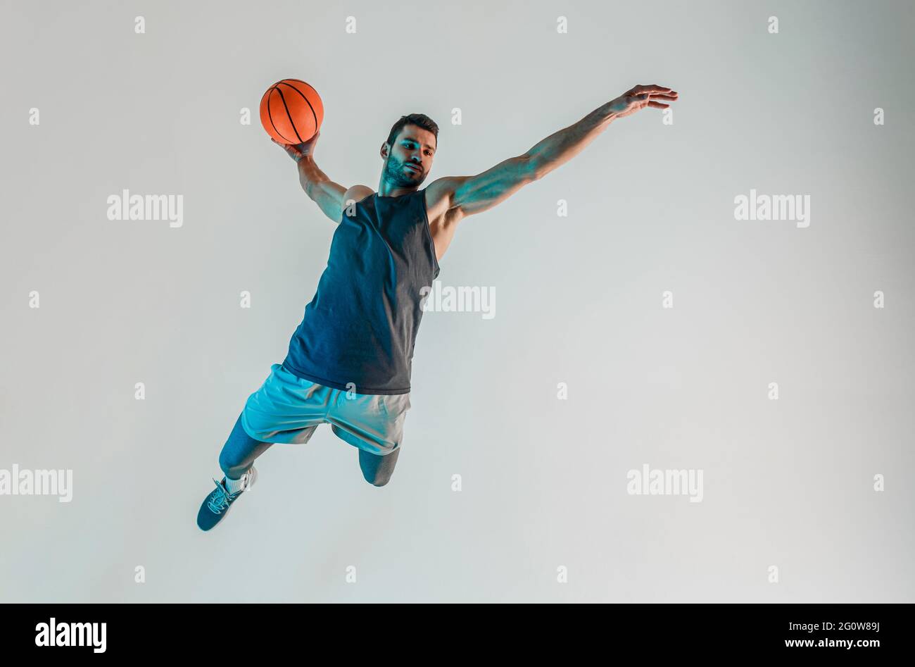 Sportler springen und wollen Basketball werfen Stockfoto