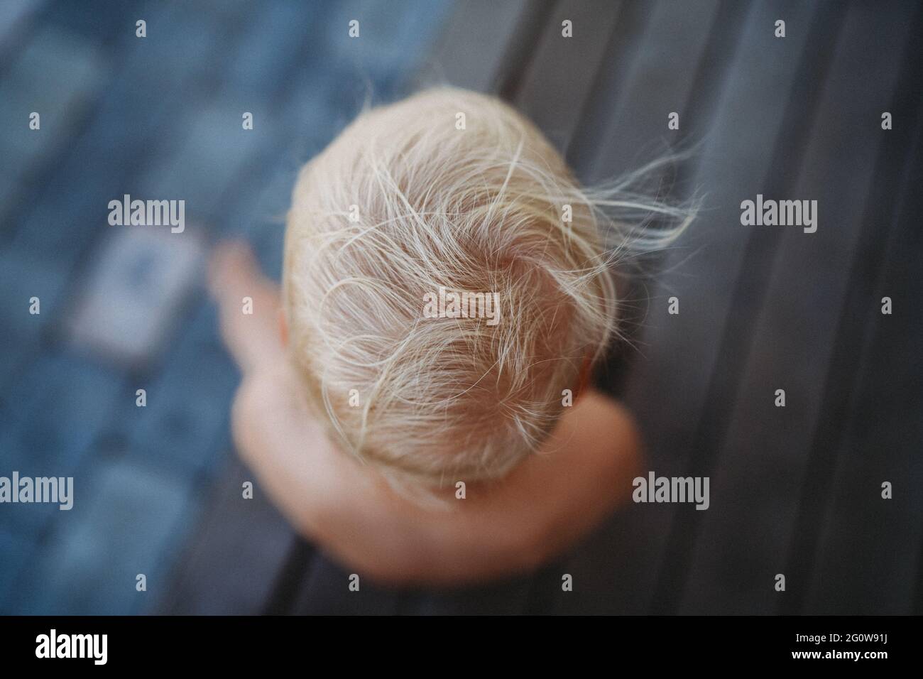 Draufsicht auf die blonden Kinderhaare im Wind draußen im Sommer Stockfoto