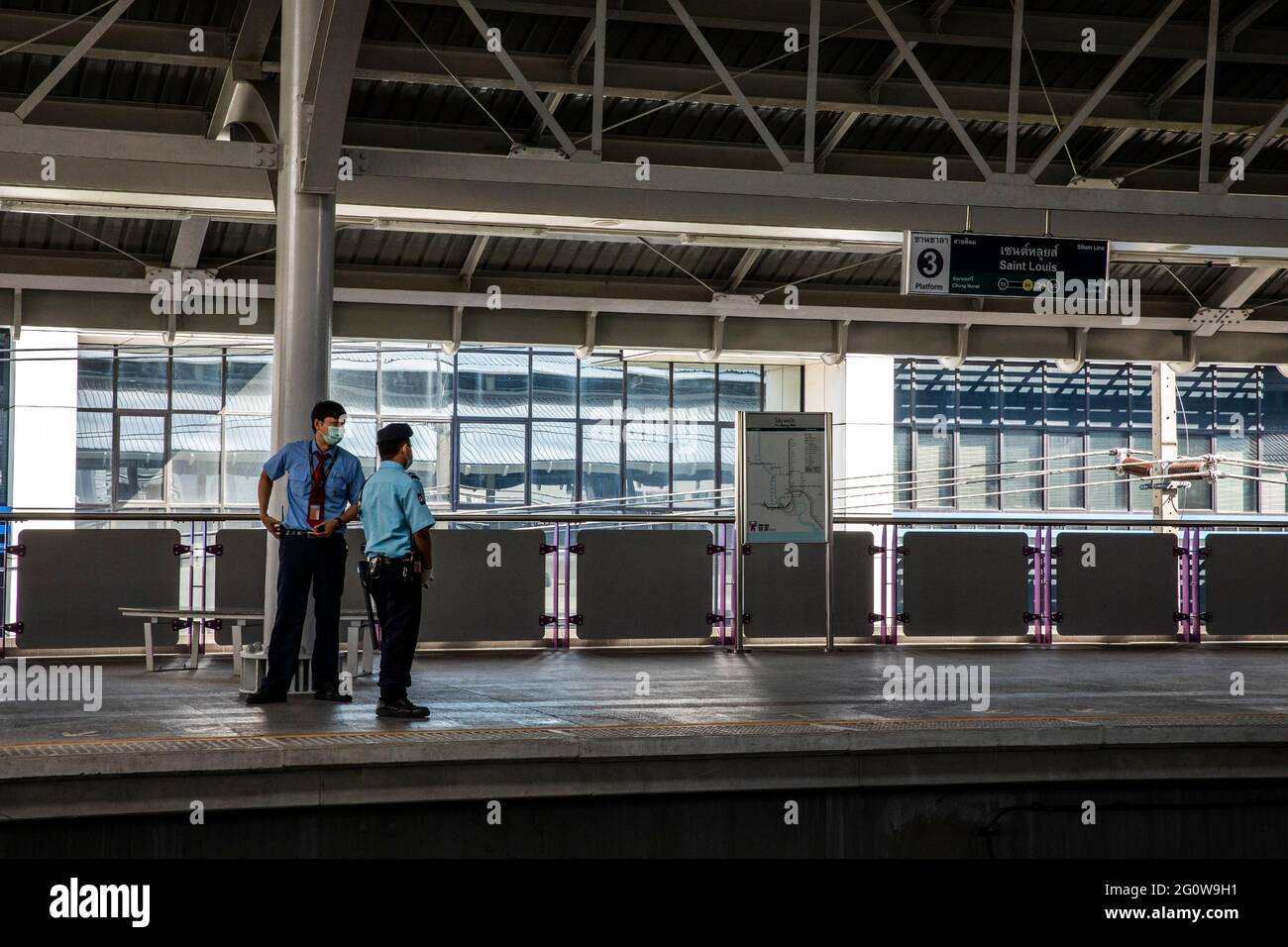 Zwei Sicherheitsbeamte wachen über EINE Skytrain-Station, die von Covid verlassen wurde Stockfoto