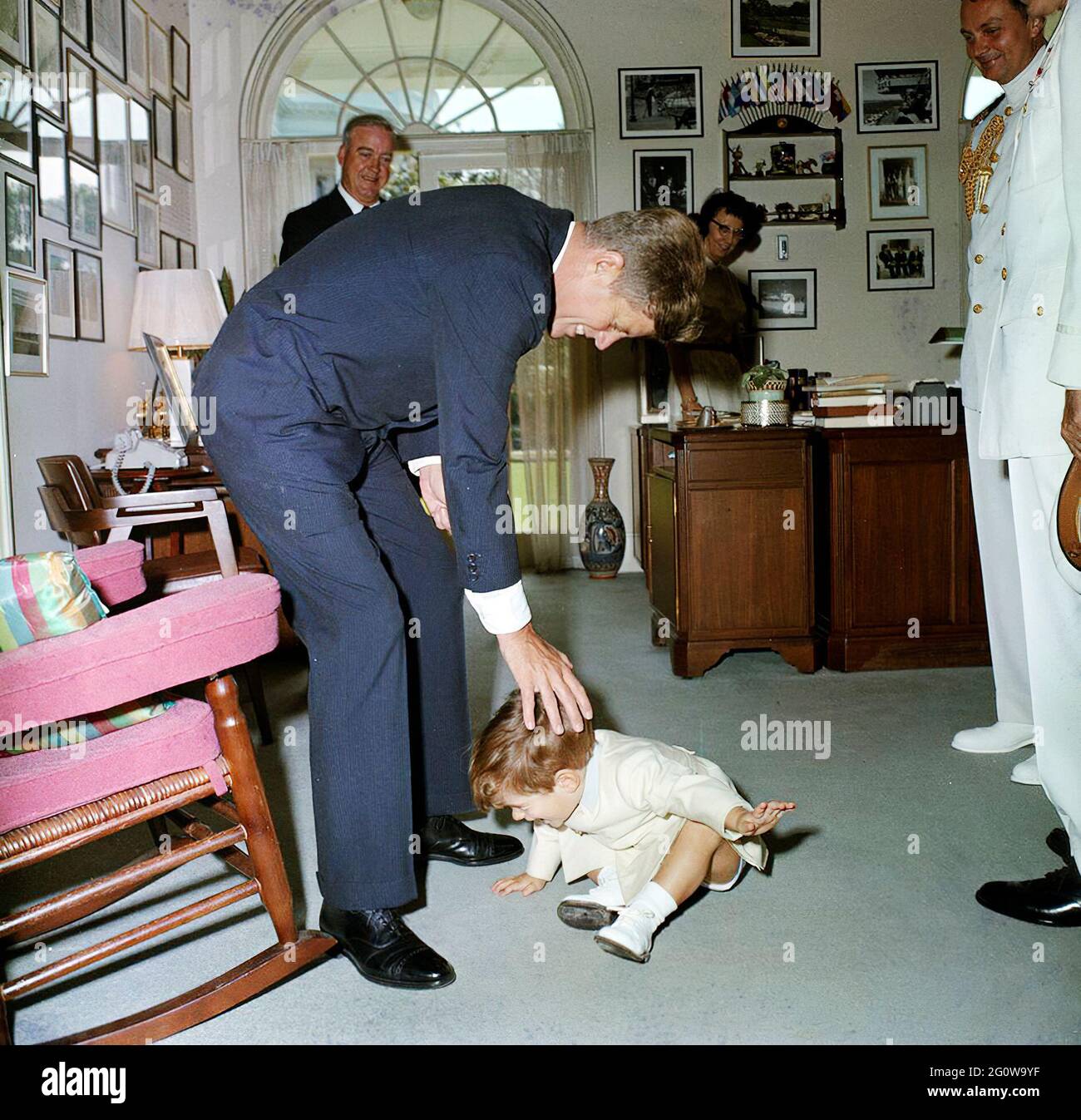 KN-C28849 30. Mai 1963 John F. Kennedy, Jr., mit Präsident Kennedy, Evelyn Lincoln, Krankenschwester Maude Shaw, Naval Aide an den Präsidenten Kapitän Tazewell Shepard, und andere im Büro des Präsidenten des Sekretärs vor Memorial Day Zeremonien [Schäden sind originell auf die negativen.] Bitte nennen Sie „Robert Knudsen. Fotografien Des Weißen Hauses. John F. Kennedy Presidential Library and Museum, Boston' Stockfoto