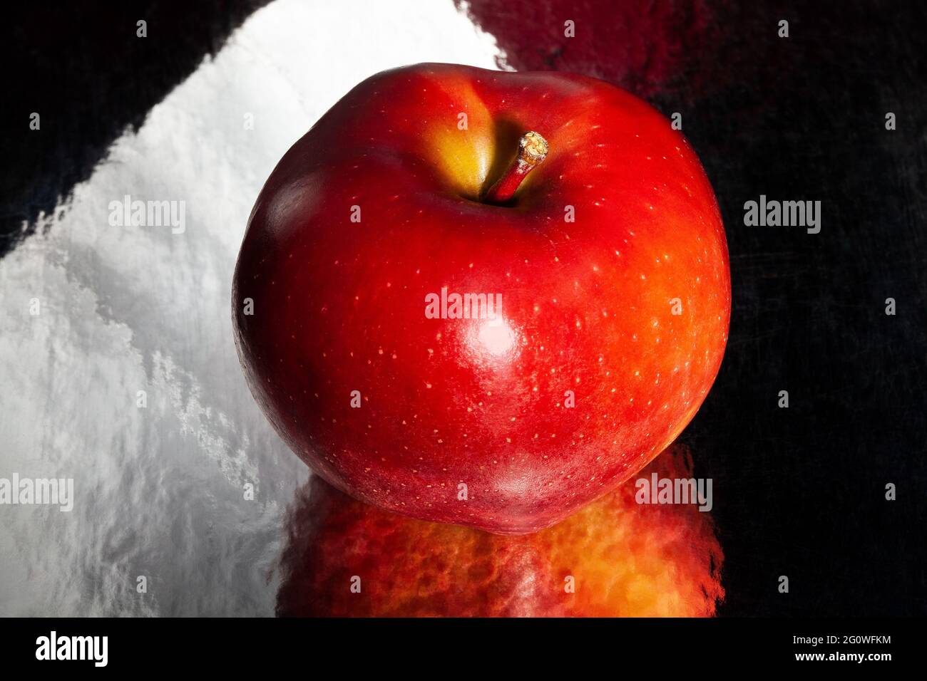 Roter köstlicher Apfel auf schwarzem reflektierendem Hintergrund Stockfoto