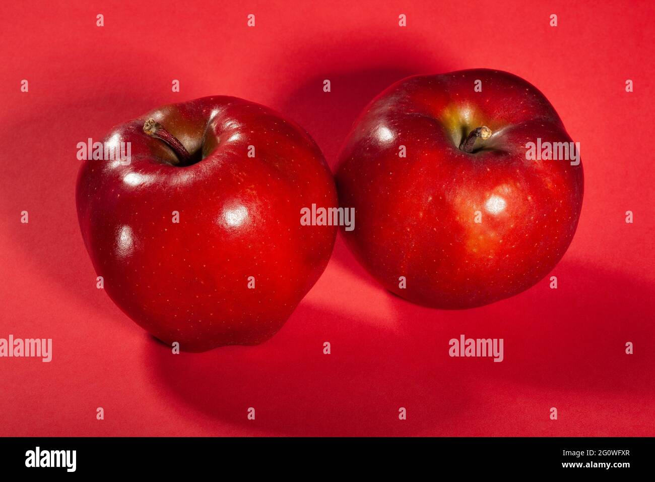 Roter köstlicher Apfel auf rotem Hintergrund Stockfoto