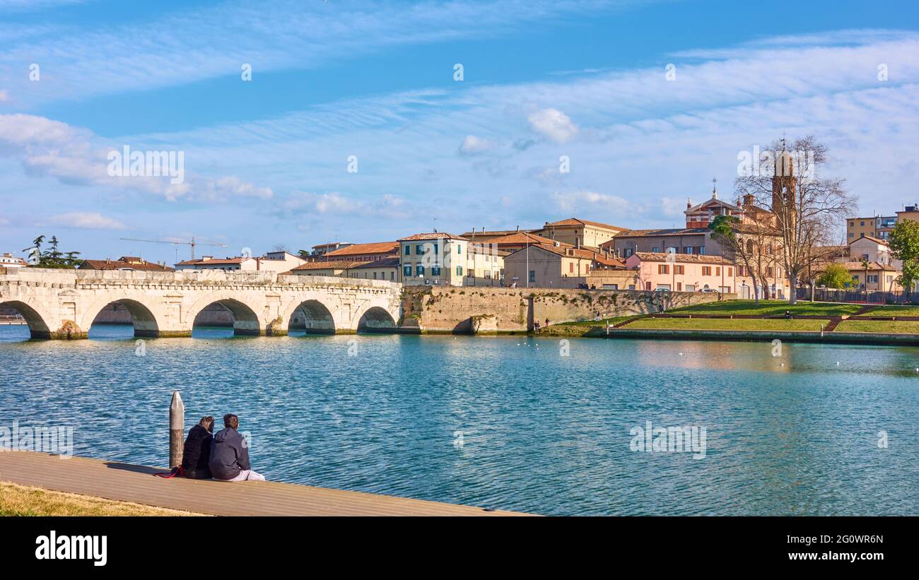 Rimini in Italien mit der Tiberius-Brücke und der Altstadt auf der anderen Flussseite. Italienisch, Panoramablick Stockfoto