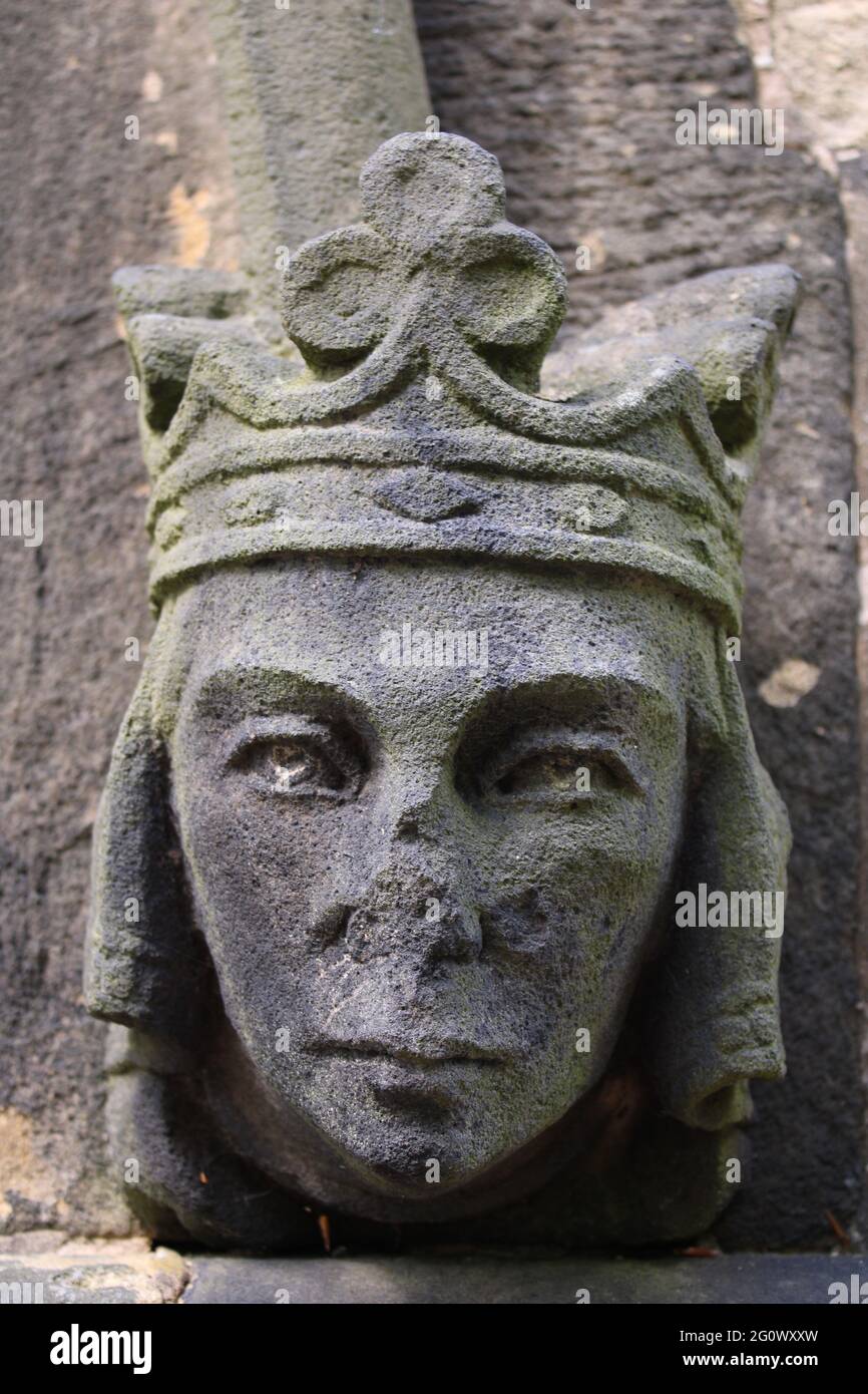 Geschnitzter Kopf mit Schäden an der Nase trägt eine Krone. Stockfoto
