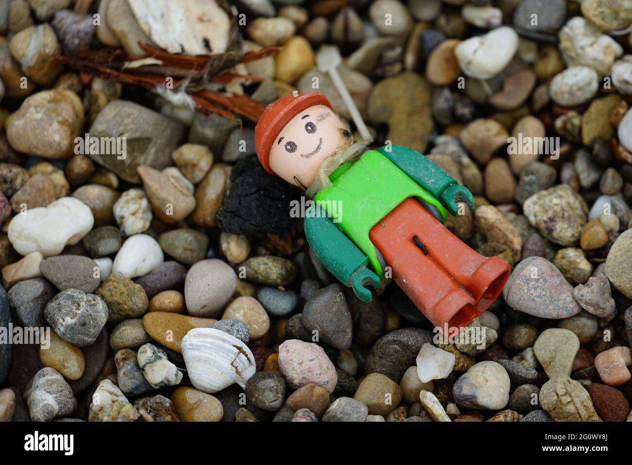 Hochwinkelige Aufnahme einer kleinen Spielzeugfigur auf den Felsen an der Küste Stockfoto