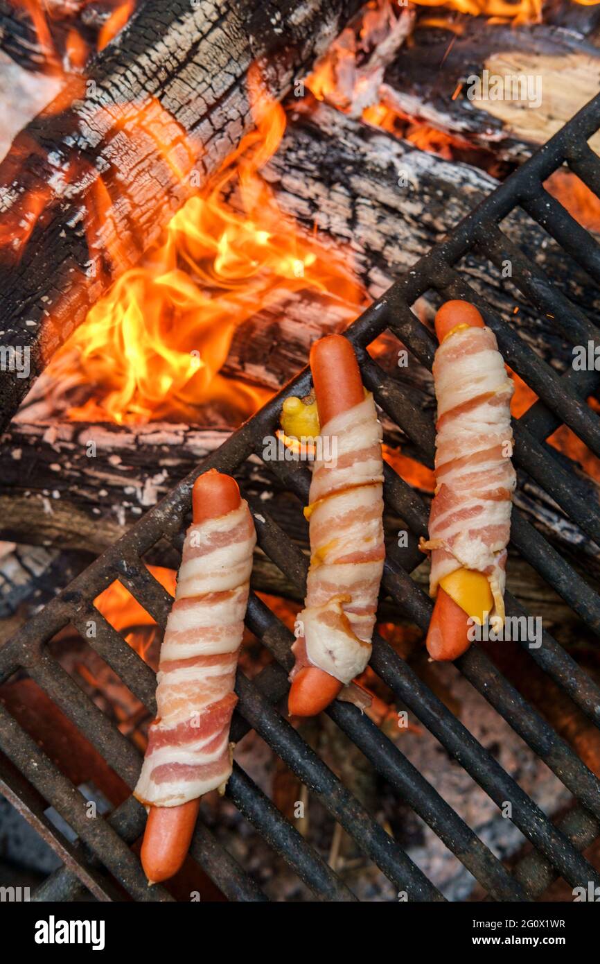 Gebratene Käse-Hot Dogs mit Speck über Lagerfeuerholz Stockfotografie ...