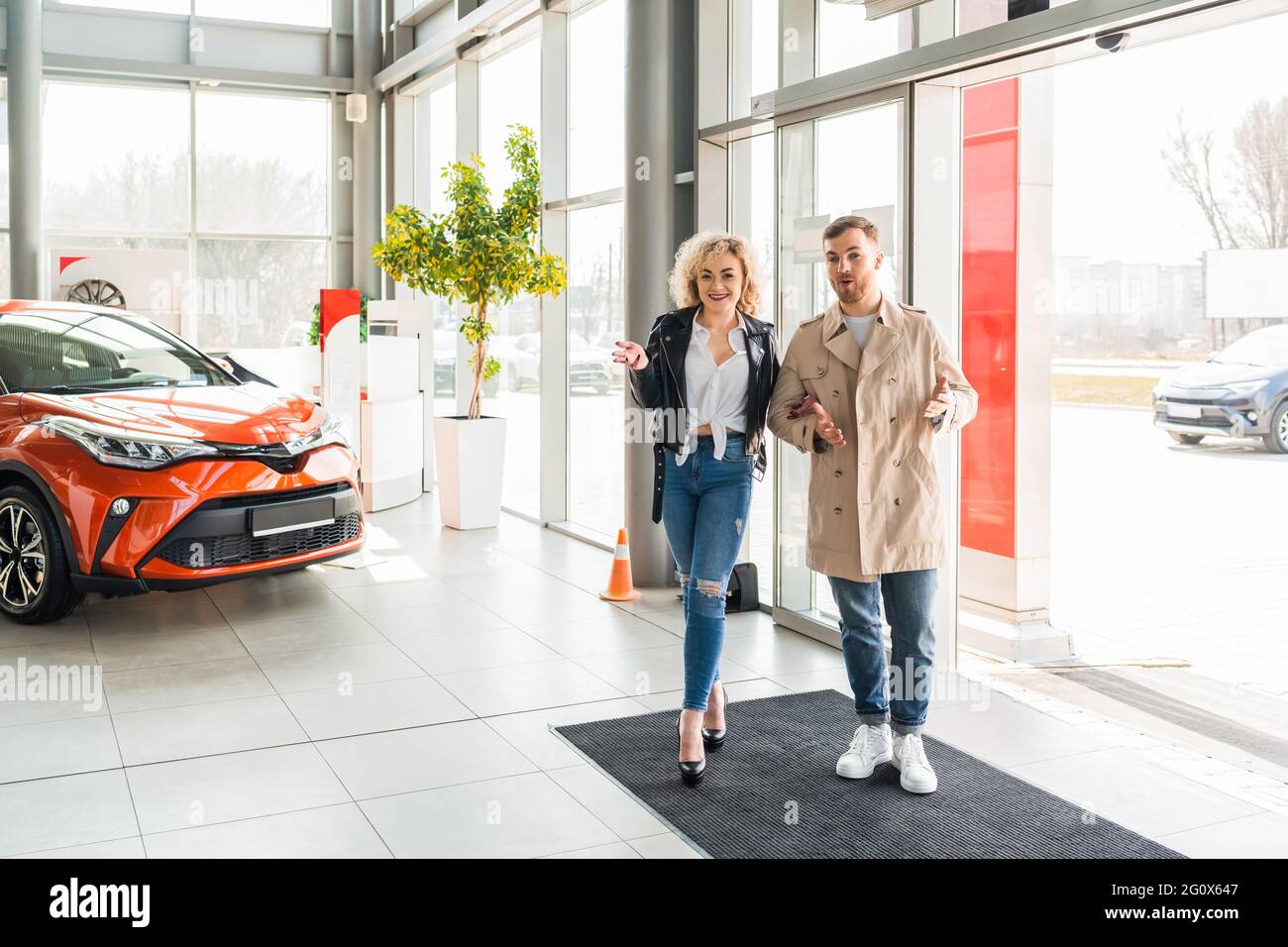 Junge schöne Paar tritt in Autohaus Stockfoto