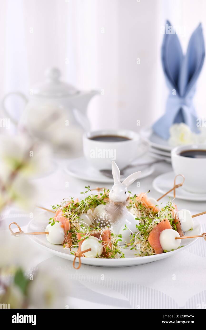 Vorspeise Wachtelei gefüllt mit Luzerne Sprossen mit einer Scheibe Lachs, auf einem Holzspieß. Buffet für den Ostertisch. Stockfoto