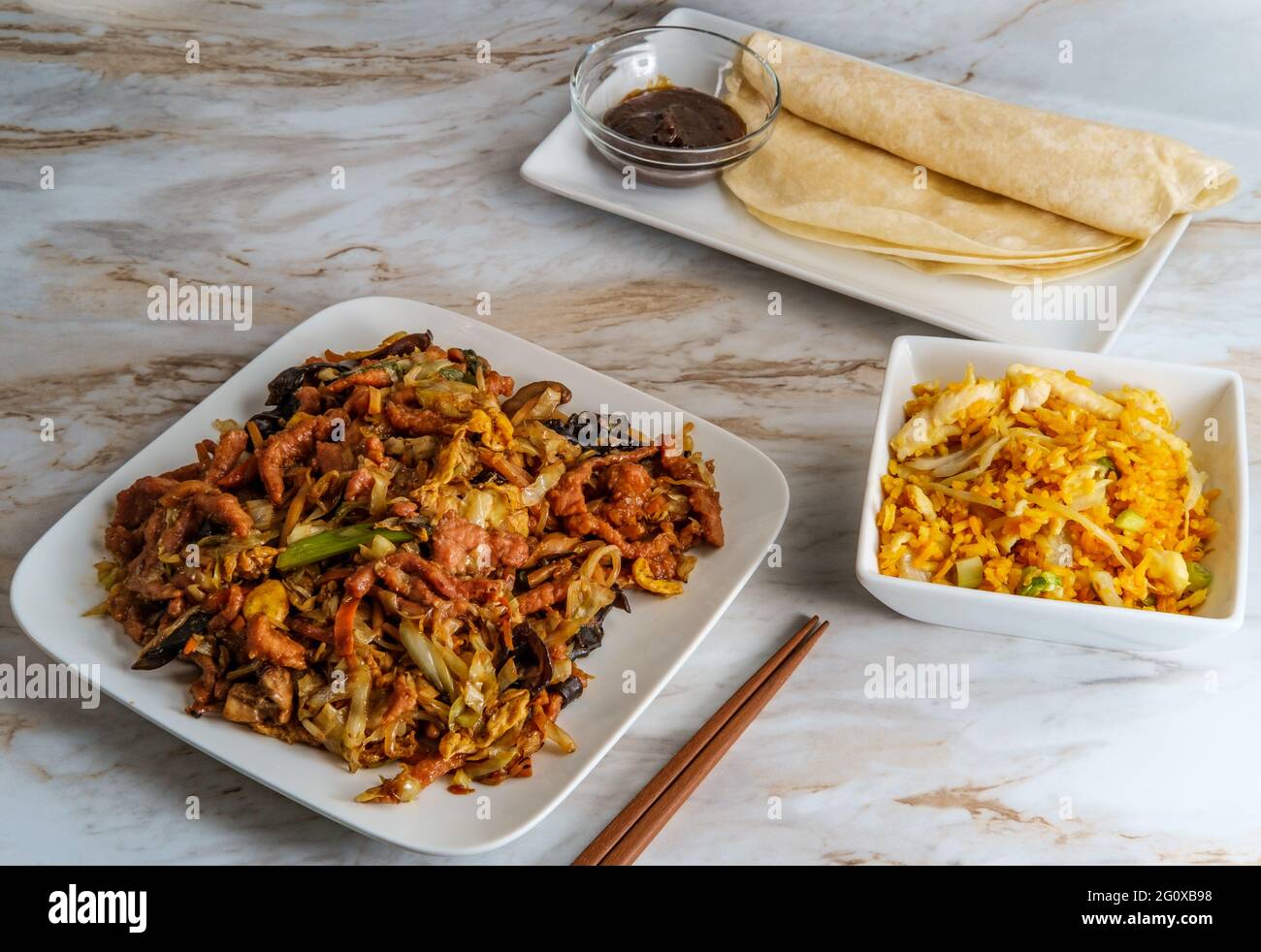 Chinesisches Essen Moo shu Schweinefleisch mit Mandarin Pfannkuchen Wrapper und schwarze Bohne hoisin Soße Stockfoto