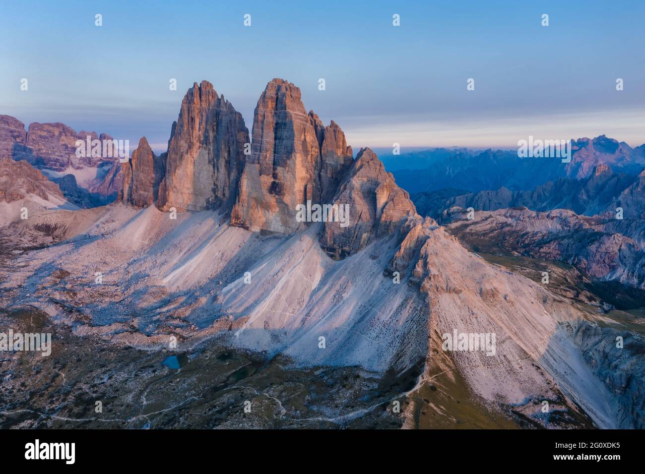 Luftaufnahme der Gipfel der Tre Cime bei rosa Sonnenuntergangslicht, Dolomiten Alpen. Nationalpark, Italien. Stockfoto