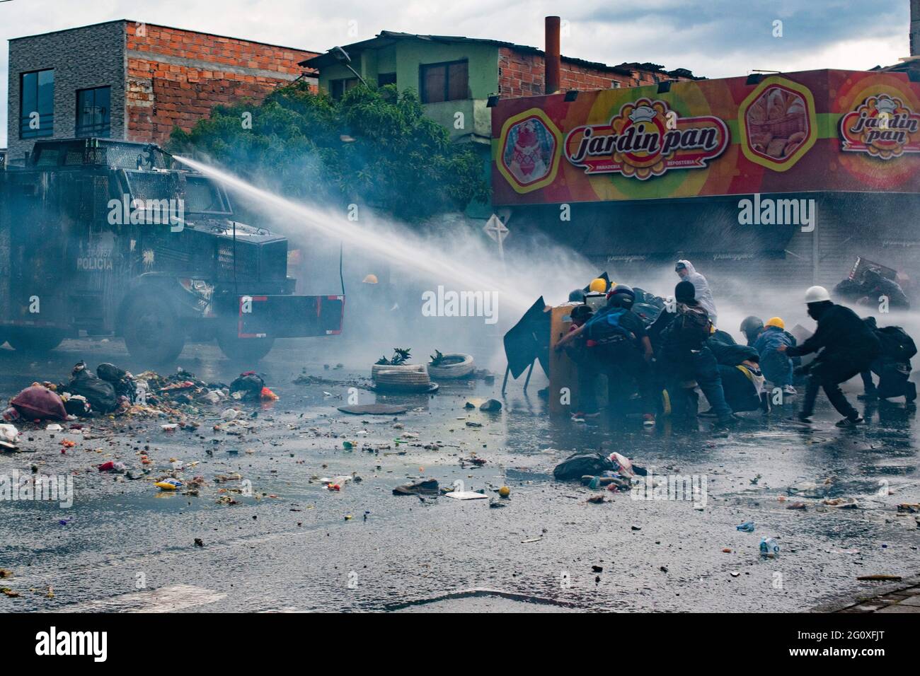 2. Juni 2021, Medellin, Antioquia, Kolumbien: Demonstranten hüten sich hinter handgefertigten Schilden, als ein bewaffnet LKW während der Zusammenstöße mit der kolumbianischen Bereitschaftspolizei (ESMAD) Wasser auf sie schießt, während regierungsfeindliche Proteste in eine 5. Woche gegen die Gesundheits- und Steuerreform von Präsident Ivan Duque ansteigen, Und Polizeimissbrauch von Behördenfällen in Medellin, Kolumbien, am 2. Juni 2021. (Bild: © Miyer Juana/LongVisual über ZUMA Wire) Stockfoto