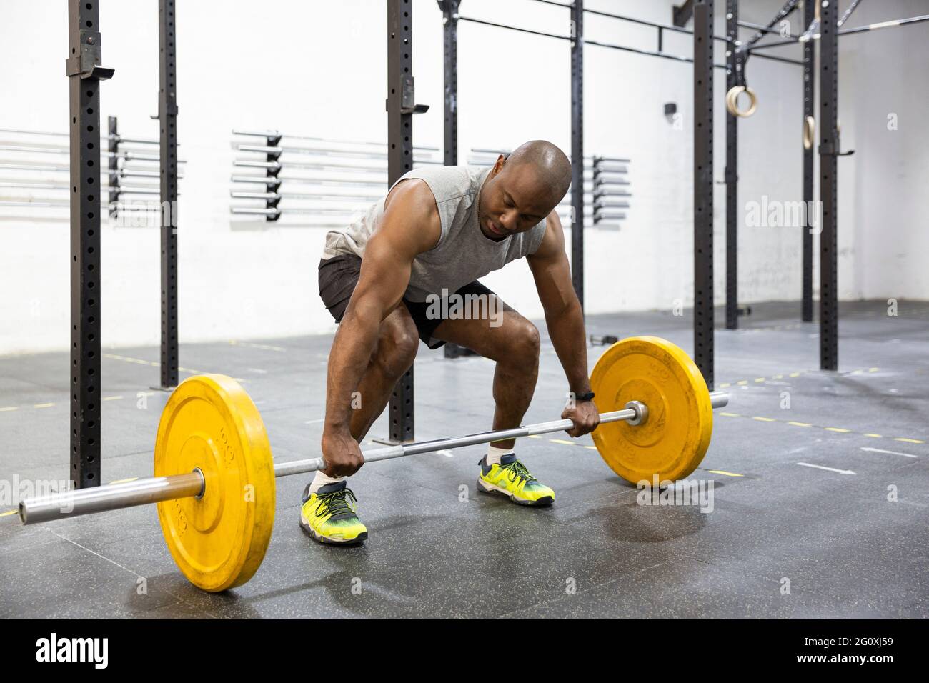 Afroamerikanischer Athlet, der sich auf das Gewichtheben vorbereitet. Training in der Turnhalle. Stockfoto