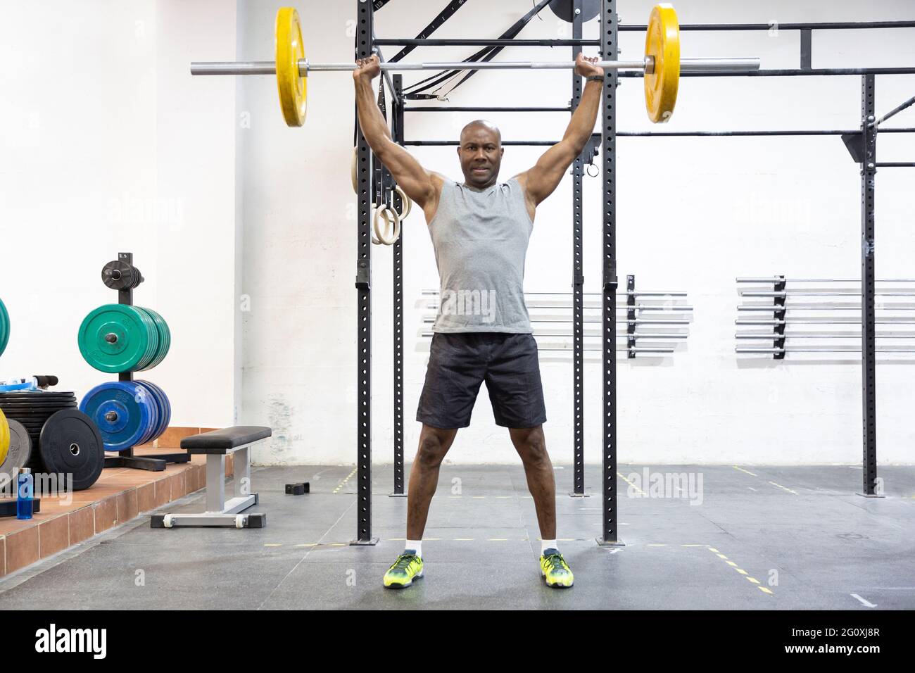 Schwarzer starker Mann, der im Fitnesscenter Gewichte hebt. Körperliches Training. Platz für Text. Stockfoto
