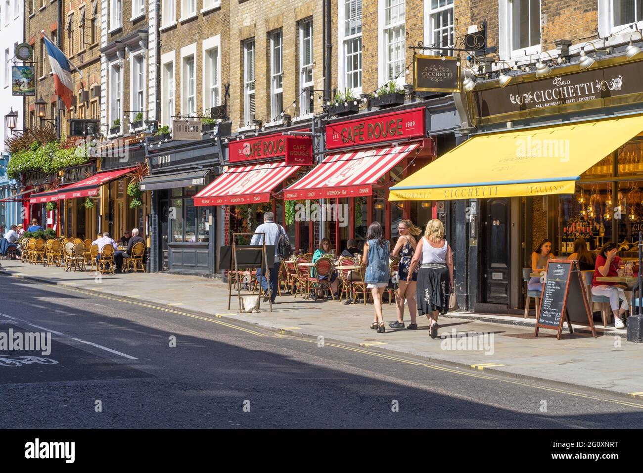 Die belebten Cafés, Restaurants und Bars in der Wellington Street in Covent Garden an einem heißen Sommertag mit Touristen, die draußen essen. London Stockfoto