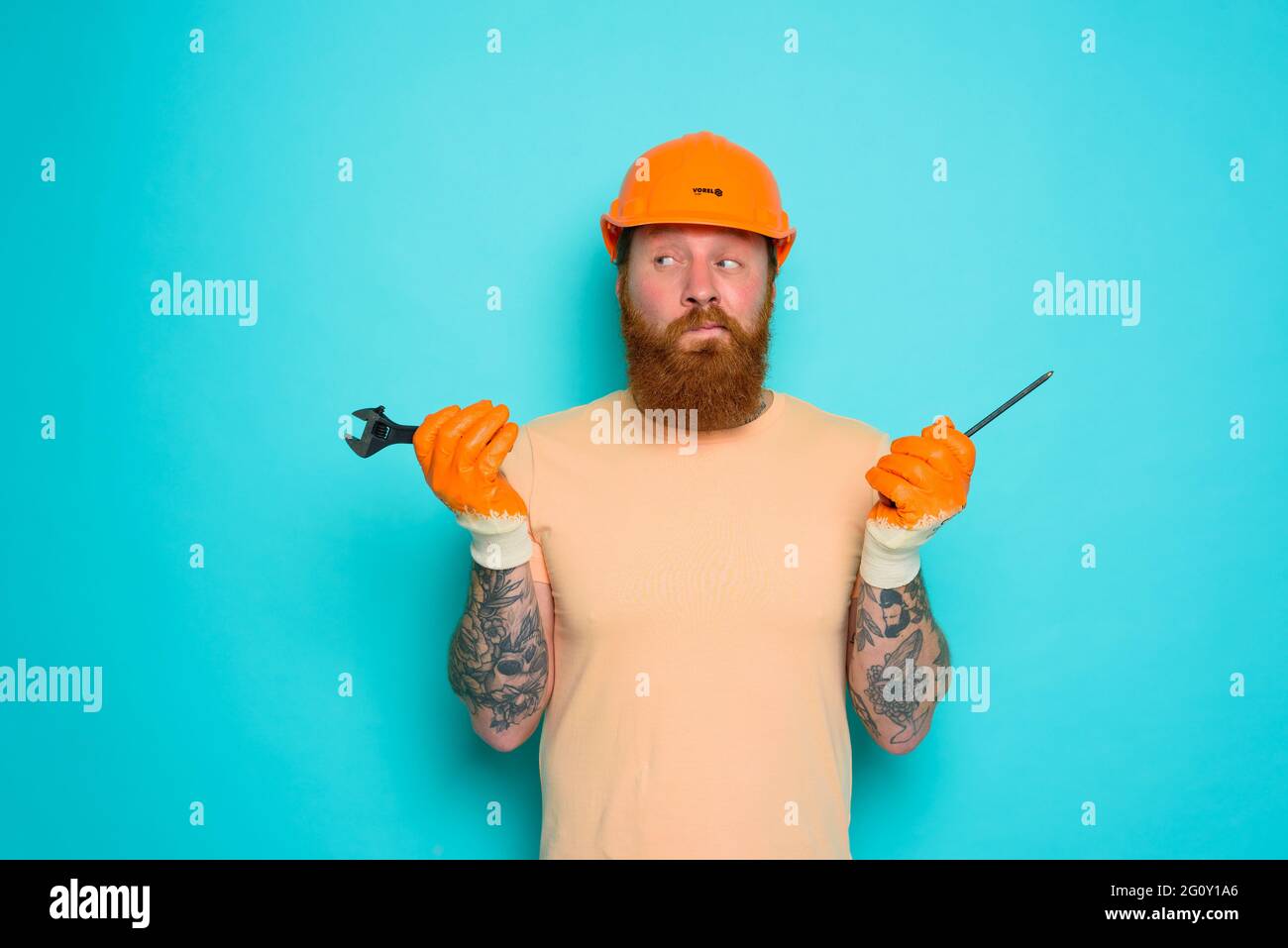 Arbeiter mit gelbem Hut ist über seine Arbeit verwirrt Stockfoto