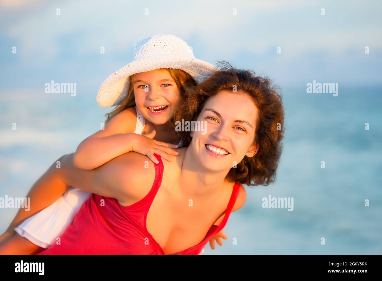 Portrait von glücklicher Mutter und kleiner Tochter am sonnigen Strand auf den Malediven im Sommerurlaub. Familie am Strand Konzept. Stockfoto