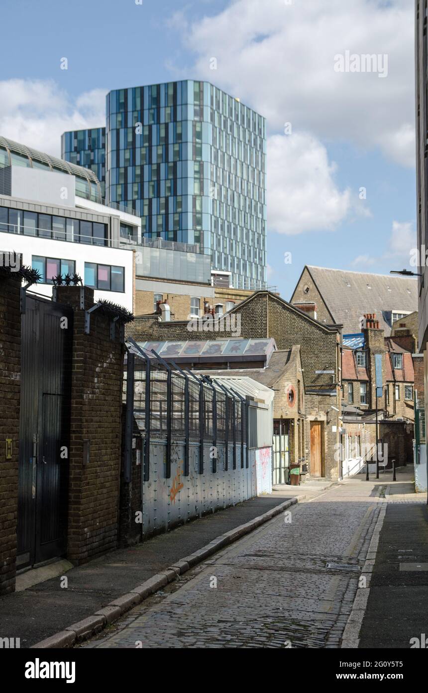 Blick entlang einer engen, gepflasterten Straße im Stadtteil Pentonville in Camden, Central London an einem sonnigen Frühlingstag. Die blauen Türme des Kapitelkönigs Stockfoto