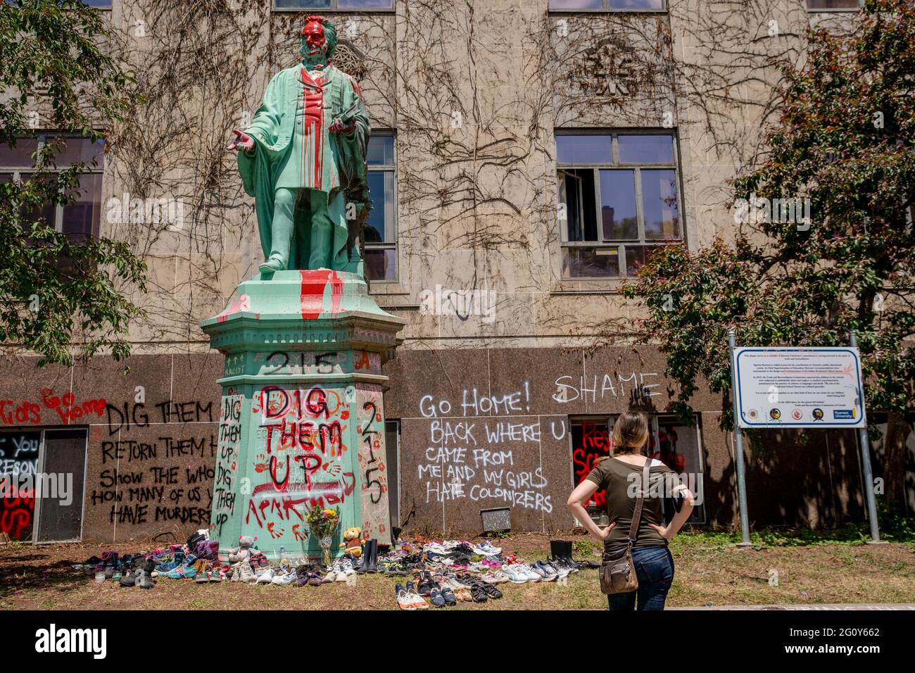 Toronto, Kanada. Juni 2021. Die Statue wurde in roter Farbe übergossen.215 Schuhe wurden um die Statue von Egerton Ryerson auf dem Campus der Ryerson University als Gedenkstätte gelegt und nach der Entdeckung von 215 Leichen von Studenten aus Wohnschulen in Kamloops, British Columbia, an einem Massengrab verwüstet. Egerton Ryerson war ein ursprünglicher Architekt des Wohnschulsystems. Kredit: SOPA Images Limited/Alamy Live Nachrichten Stockfoto