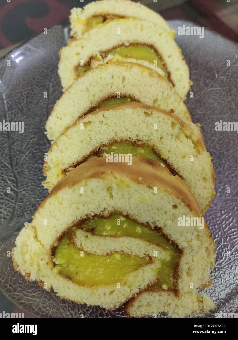 Eine Schweizer Rolle, Geleerolle, Kuchenrolle, Sahnerolle, Roulade oder Schweizer Log ist eine Art gerollter Biskuitkuchen, der mit Schlagsahne, Marmelade oder Glasur gefüllt ist Stockfoto
