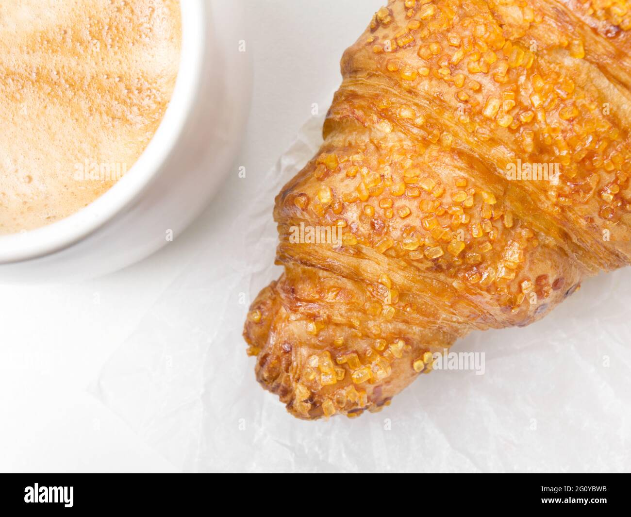 Gebäck Croissant auf weißem Papier Hintergrund mit einer Tasse Kaffee. Französisches Essen Stockfoto