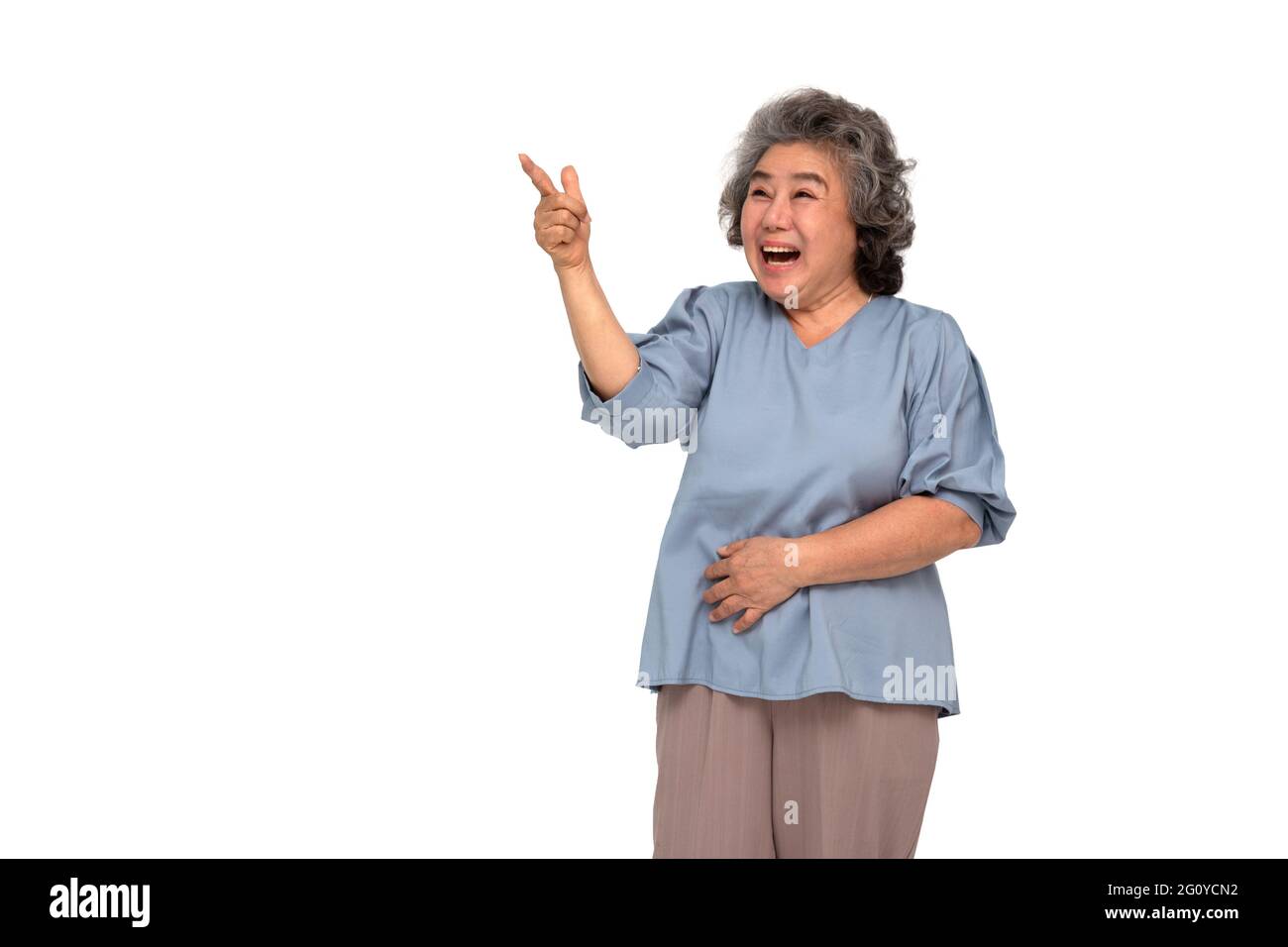 Porträt einer aufgeregt schreienden asiatischen älteren Frau stehend und Zeigefinger, um den Raum isoliert auf weißem Hintergrund zu kopieren, Wow und überrascht Konzept Stockfoto