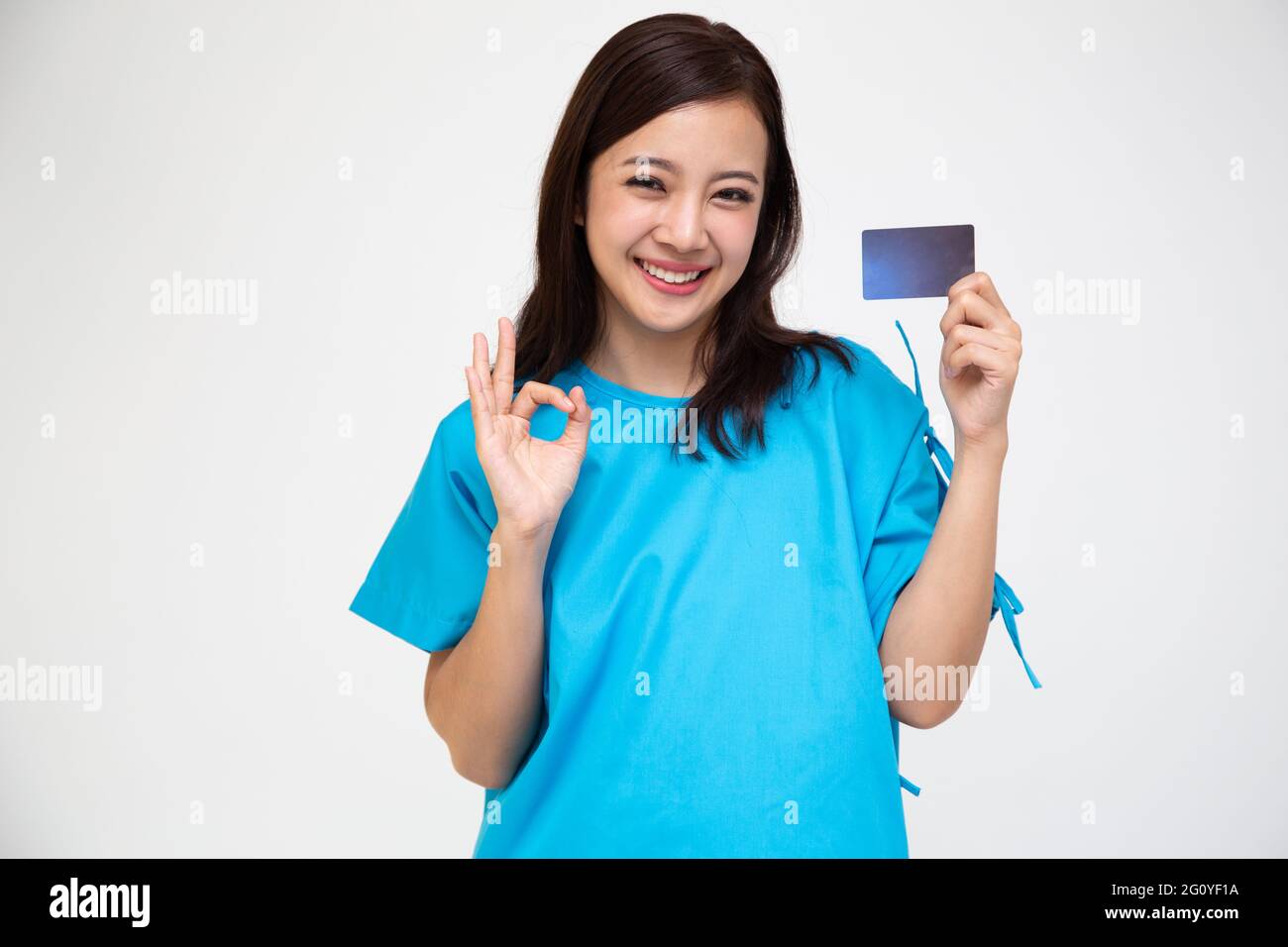 Junge asiatische schöne Frau Patient zeigt persönliche Unfallversicherung Pflegekarte und ok Zeichen isoliert auf weißem Hintergrund, PA und Gesundheit Anspruch Service Stockfoto