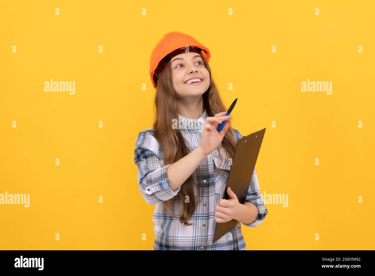 Kindheitsentwicklung. Glücklicher Arbeitstag. Zukünftige Karriere. Teen Mädchen im Helm Notizen machen. Stockfoto