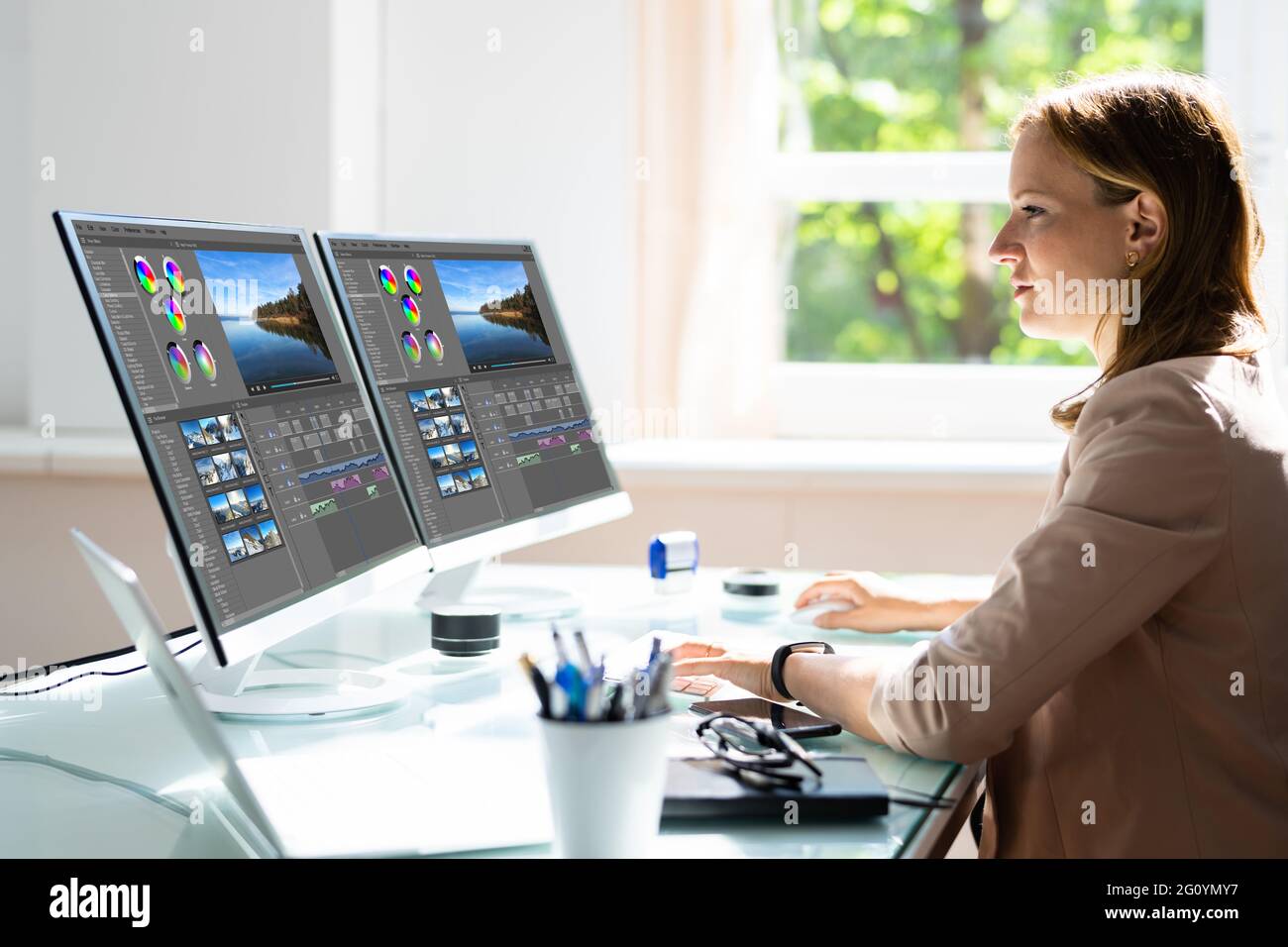 Junge weibliche Editor Videobearbeitung am Computer im Büro Stockfoto