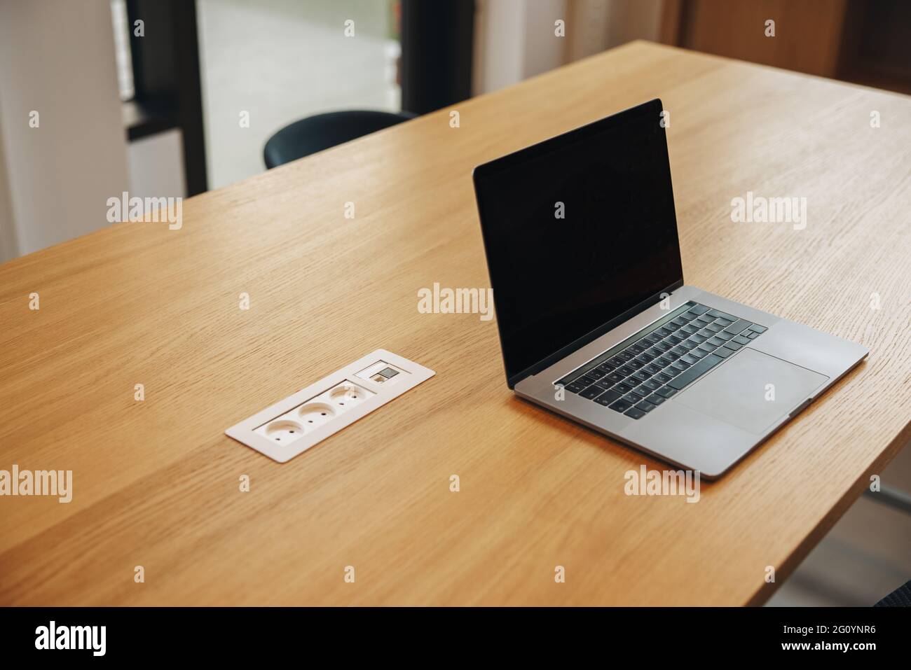 Laptop mit schwarzem Bildschirm im Büro-Konferenzraum. Tisch im Tagungsraum mit offenem Laptop. Stockfoto