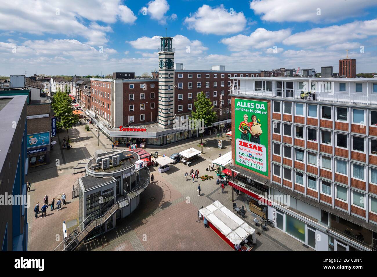 Deutschland, Oberhausen, Oberhausen-Sterkrade, Ruhrgebiet, Niederrhein, Rheinland, Nordrhein-Westfalen, NRW, Sterkrade Innenstadt, Kreuzung Bahnhofstrasse und Steinbrinkstrasse, Stadtmittehaus und Glockenturm, Mittelpunkt, Pavillon der Schlachterei Reuschenbach, Wohn- und Geschäftshäuser, Wochenmarkt, rechts der Kirchturm der Propstkirche St. Clemens Stockfoto
