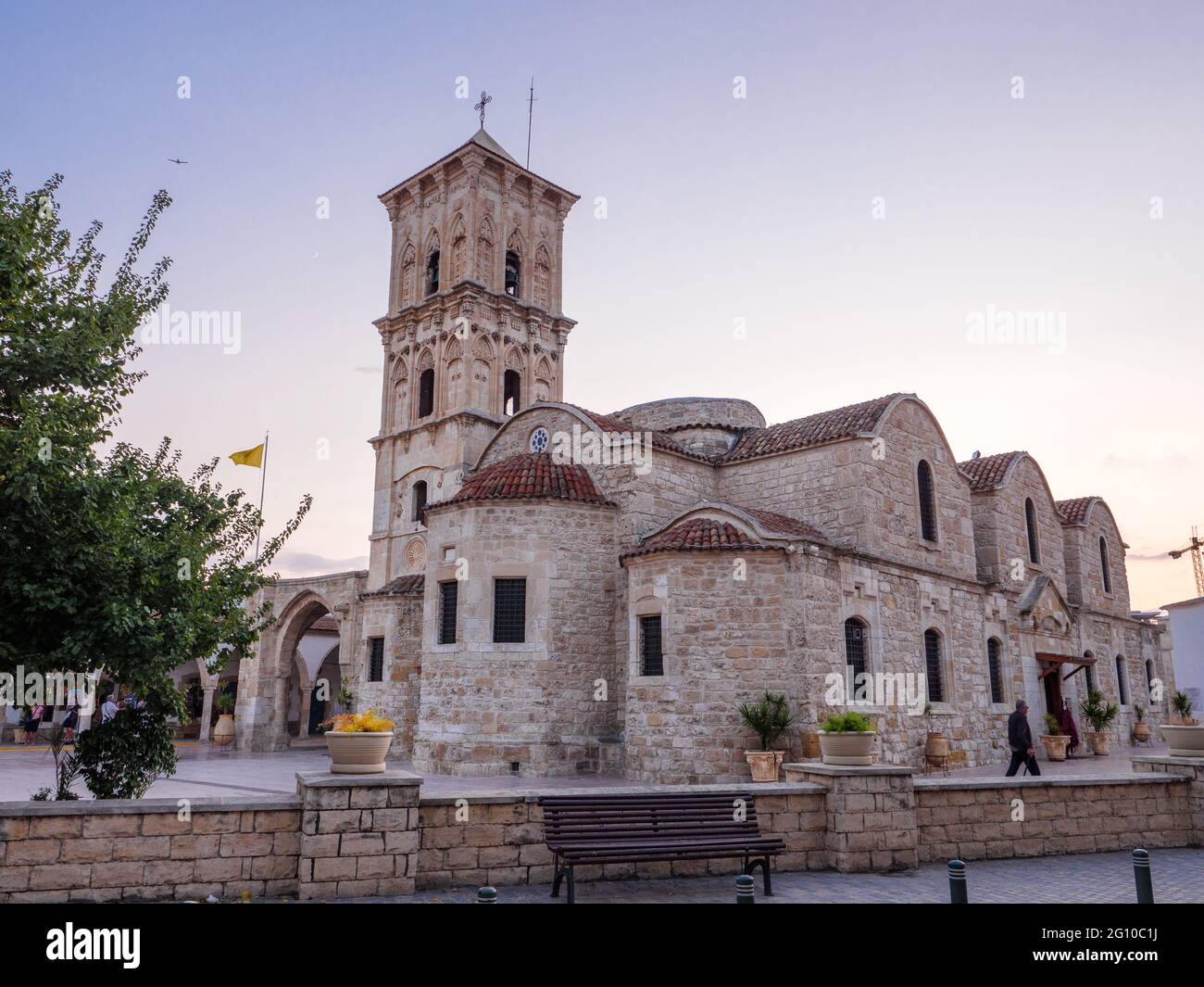 Alte Stein st. Lazarus Kirche auf dem zentralen Platz der Larnaka Altstadt in Zypern. Leute, die herumlaufen, Bank an der Vorderseite. Historisches Erbe. Stockfoto