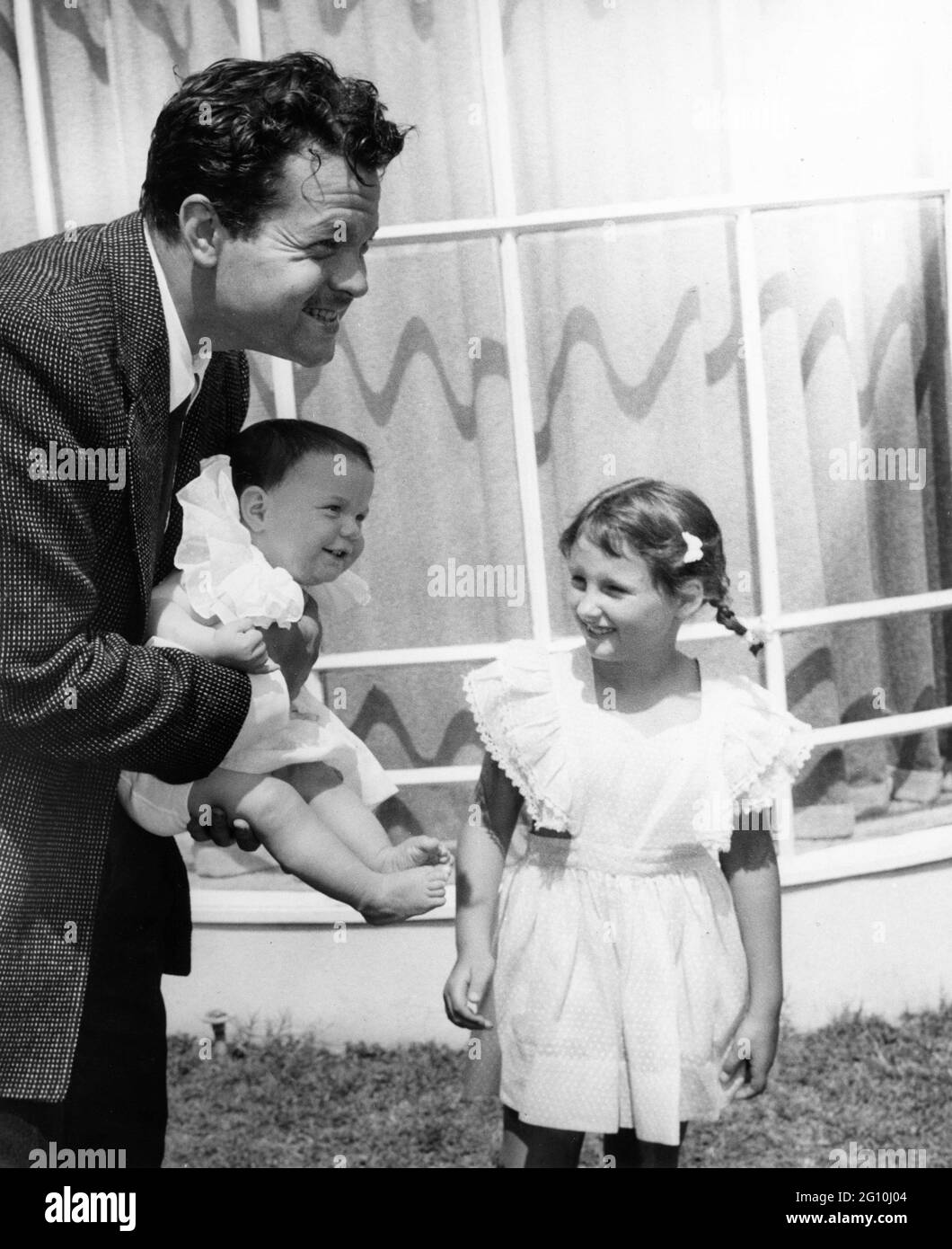 ORSON WELLES in seinem Haus in Hollywood mit seinen Töchtern REBECCA WELLES (aus seiner 2. Ehe mit RITA HAYWORTH) und CHRISTOPHER WELLES (aus seiner 1. Ehe mit VIRGINIA NICOLSON) um das Jahr 1945 für International Picturs / RKO Radio Pictures Stockfoto