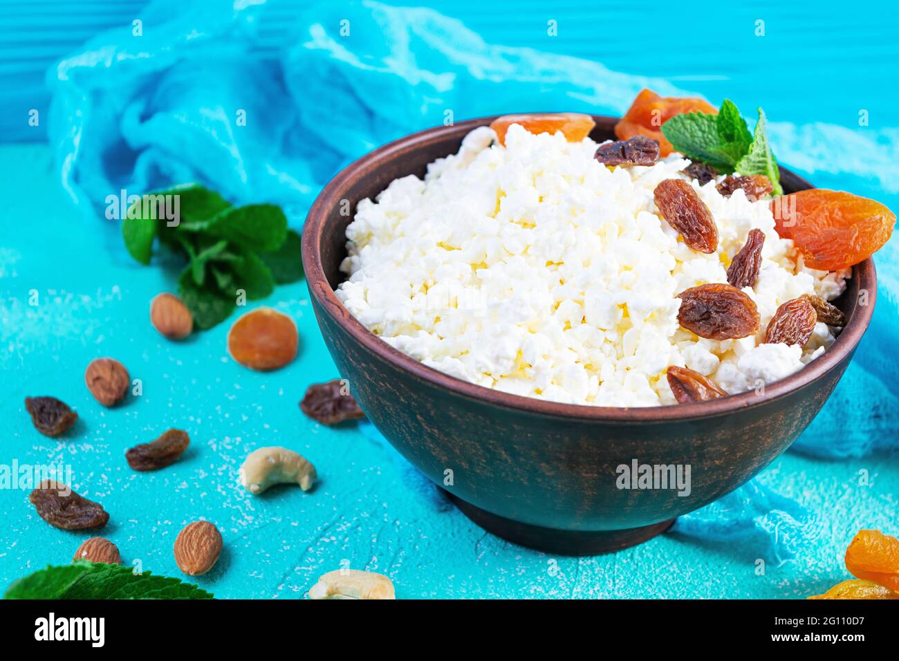 Gesundes Frühstück Hüttenkäse mit Rosinen, getrockneten Aprikosen, Mandel, Cashew und Minze Stockfoto