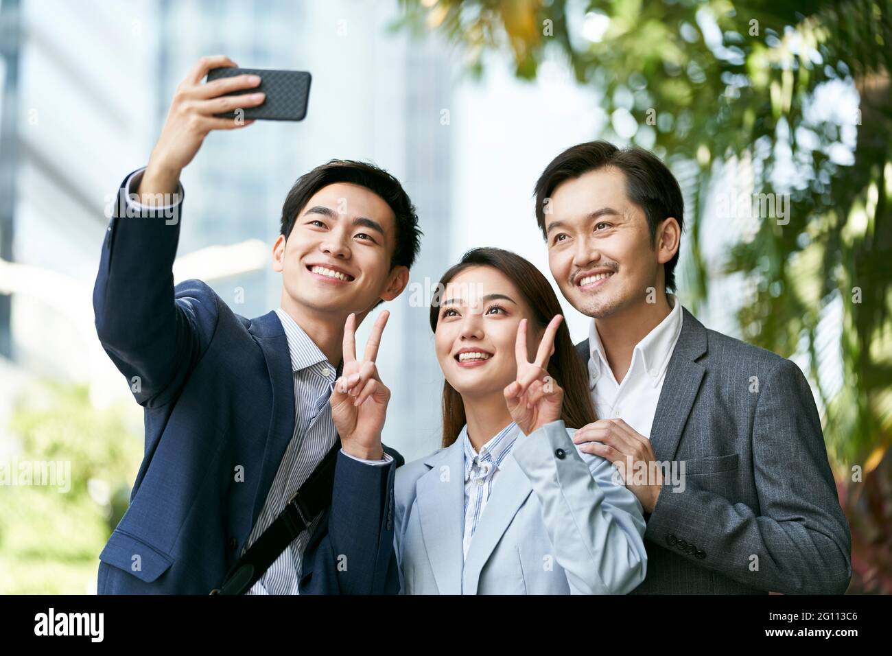 Team aus drei asiatischen Geschäftsleuten, die ein Selfie in der Innenstadt machen Finanzviertel der modernen Stadt Stockfoto