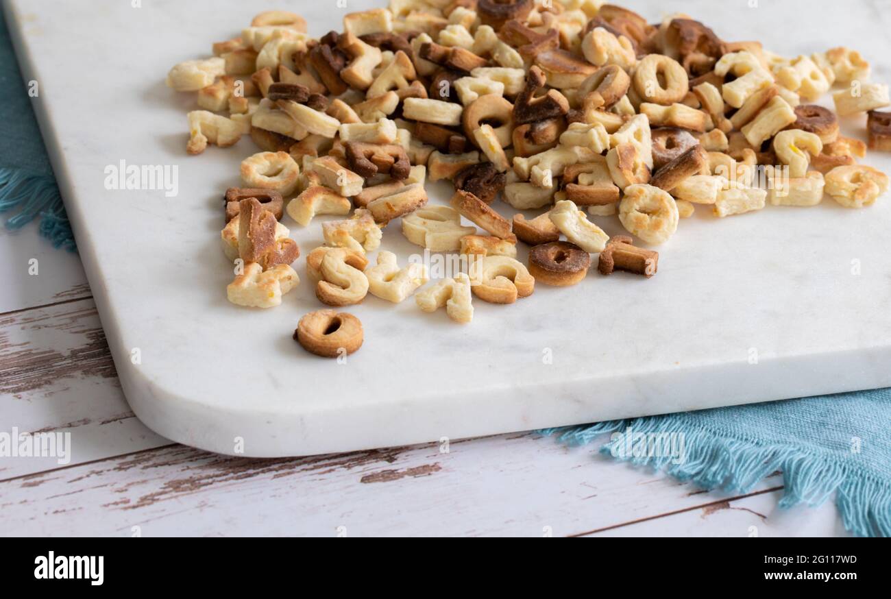 Stapel von Briefen aus frisch gekochten Plätzchen, bereit zum Vereisen auf einem Marmorplatte bei natürlichem Licht Stockfoto