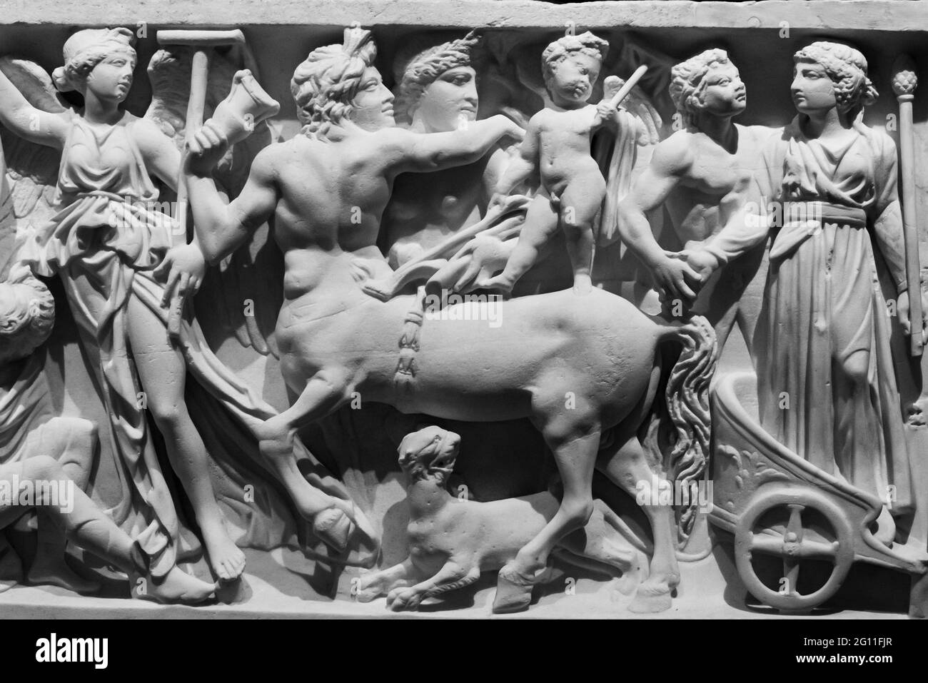 Schwarz-Weiß-Foto von antiken römischen Skulpturen, die eine mythologische Kampfszene darstellen, die auf einer Marmorwand eingraviert ist Stockfoto