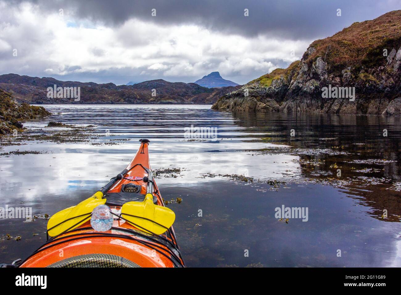 Kajakfahren auf dem Meer vor der Küste von Nordwestschottland Stockfoto